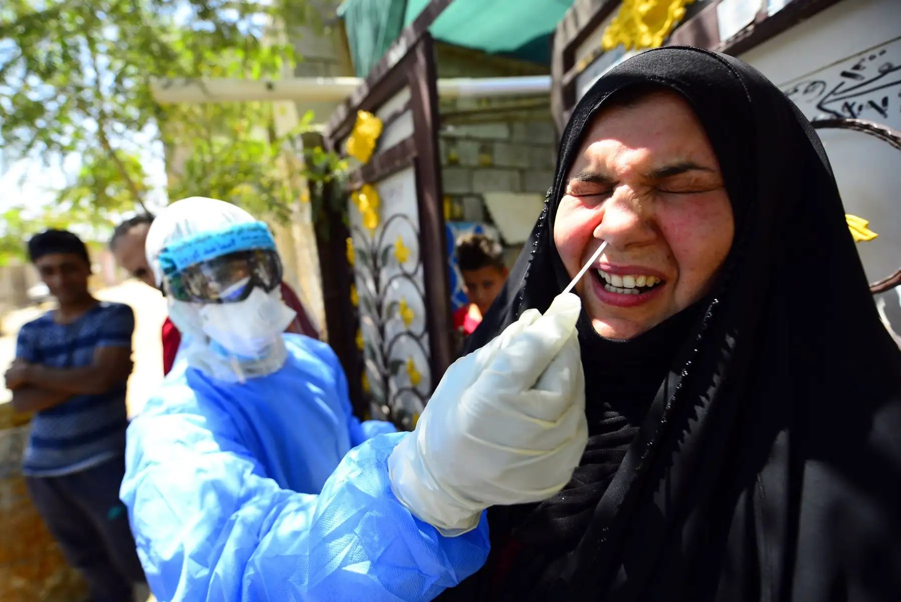 Un médico iraquí toma una muestra nasal de una mujer en el santuario central de la ciudad iraquí de Najaf el 20 de abril de 2020, durante el cierre nacional para detener la propagación del nuevo coronavirus. Foto: AFP
