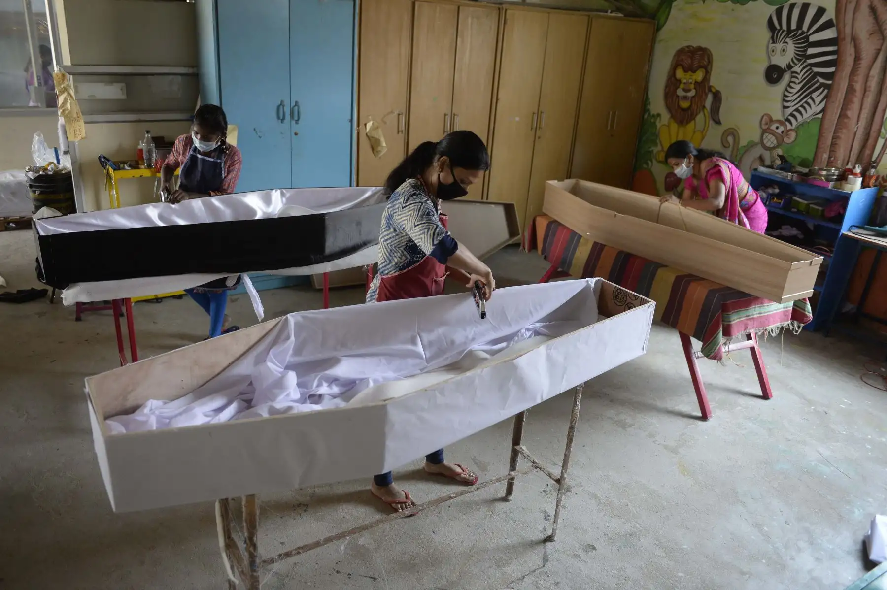Los trabajadores hacen ataúdes en el taller de una empresa de servicios funerarios durante un cierre nacional impuesto por el gobierno como medida preventiva contra el coronavirus COVID-19, en Secunderabad. Foto: AFP