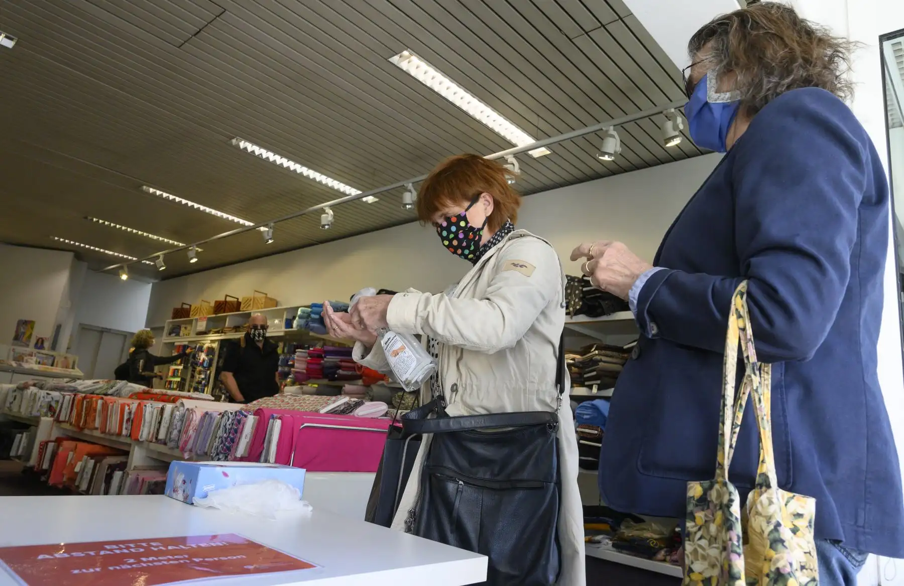 Una mujer que usa máscaras faciales desinfecta sus manos cuando ingresa a una tienda de telas en Ludwigsburg, sur de Alemania, en medio de la nueva pandemia de coronavirus COVID-19. Foto: AFP