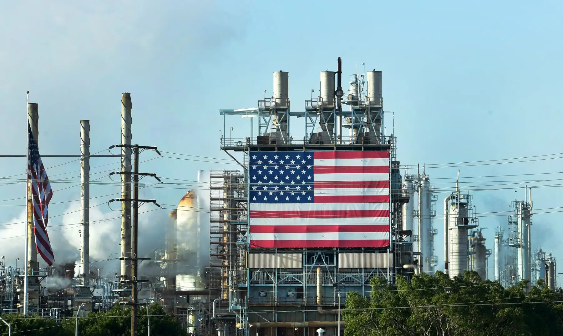 La bandera de EE. UU. se muestra en los campos petrolíferos de Wilmington, al sur de Los Ángeles, California, el 21 de abril de 2020, un día después de que los precios del petróleo cayeron por debajo de cero. Foto: AFP