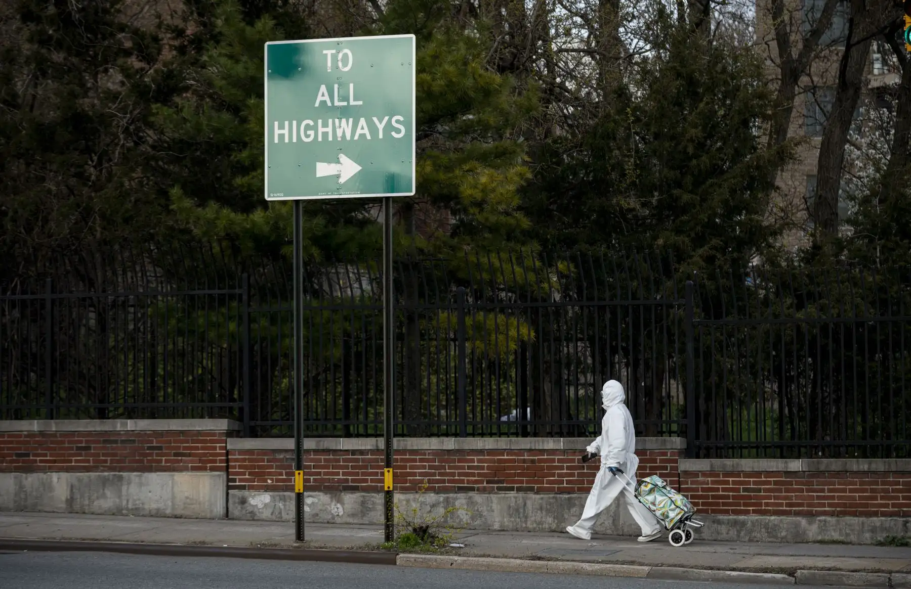 Una mujer vestida con un traje protector y protectores de ojos tira su carrito de compras en las calles de Queens, un distrito de la ciudad de Nueva York en medio de la pandemia de coronavirus. Foto: AFP