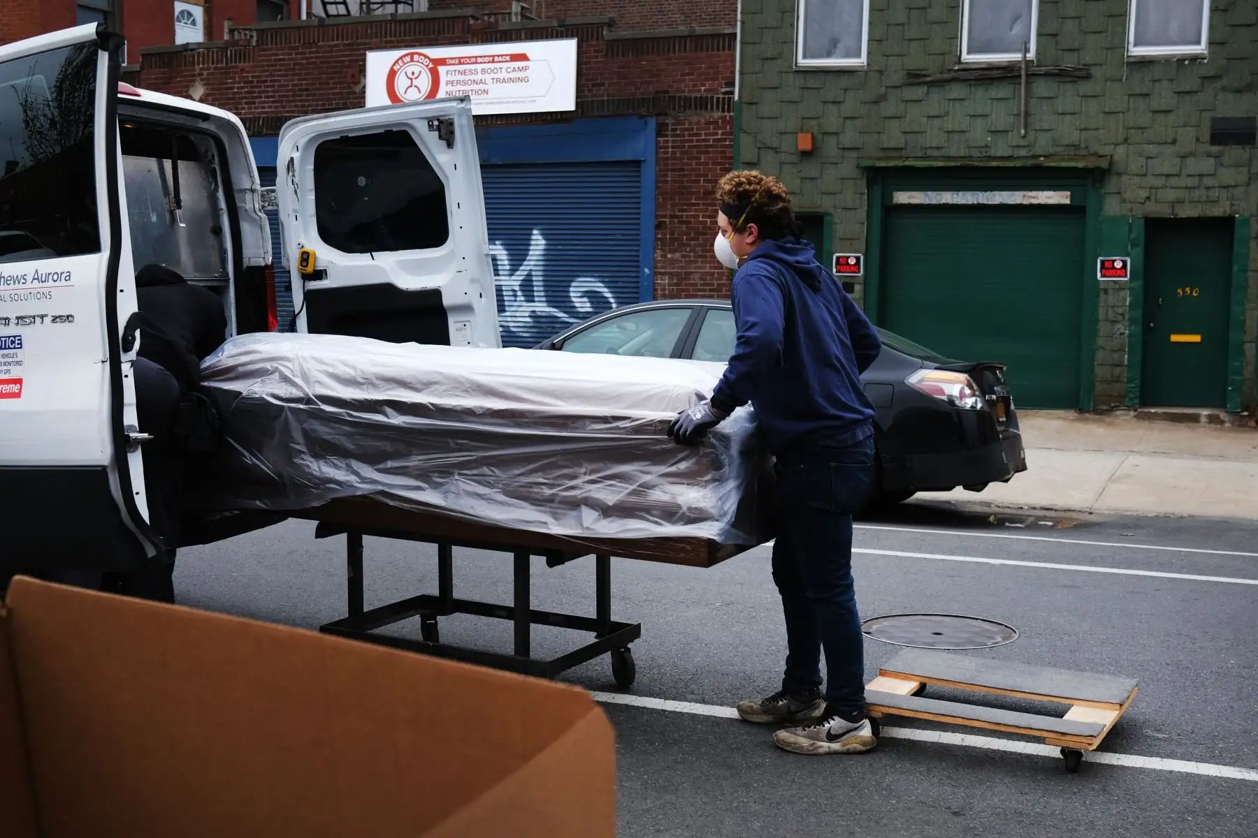 Los trabajadores de Matthews Casket Division cargan un ataúd en una camioneta en Brooklyn el 21 de abril de 2020 en la ciudad de Nueva York. Foto: AFP