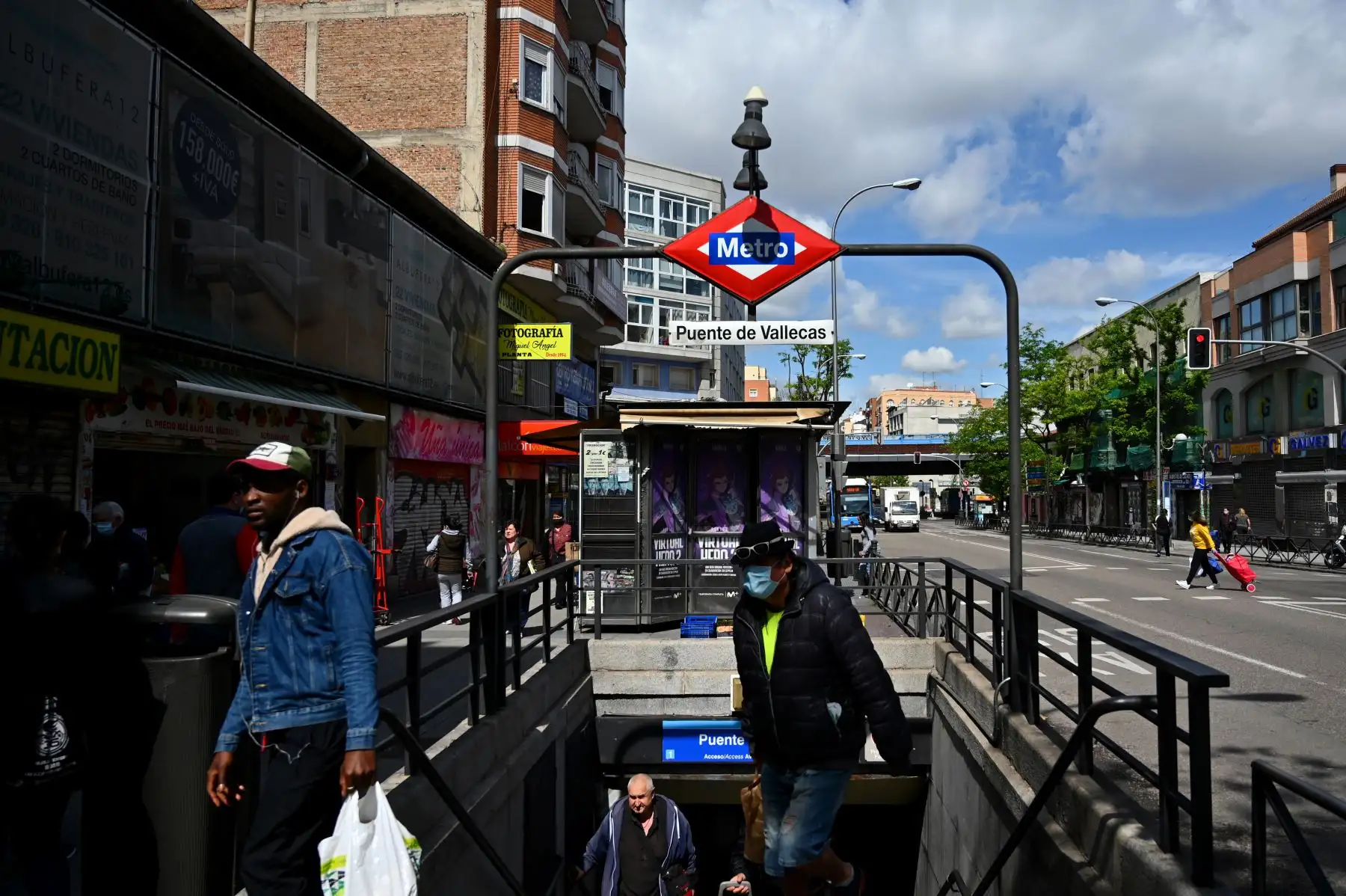 La gente camina por una entrada de metro en Puente de Vallecas, uno de los distritos más pobres de Madrid. Foto: AFP