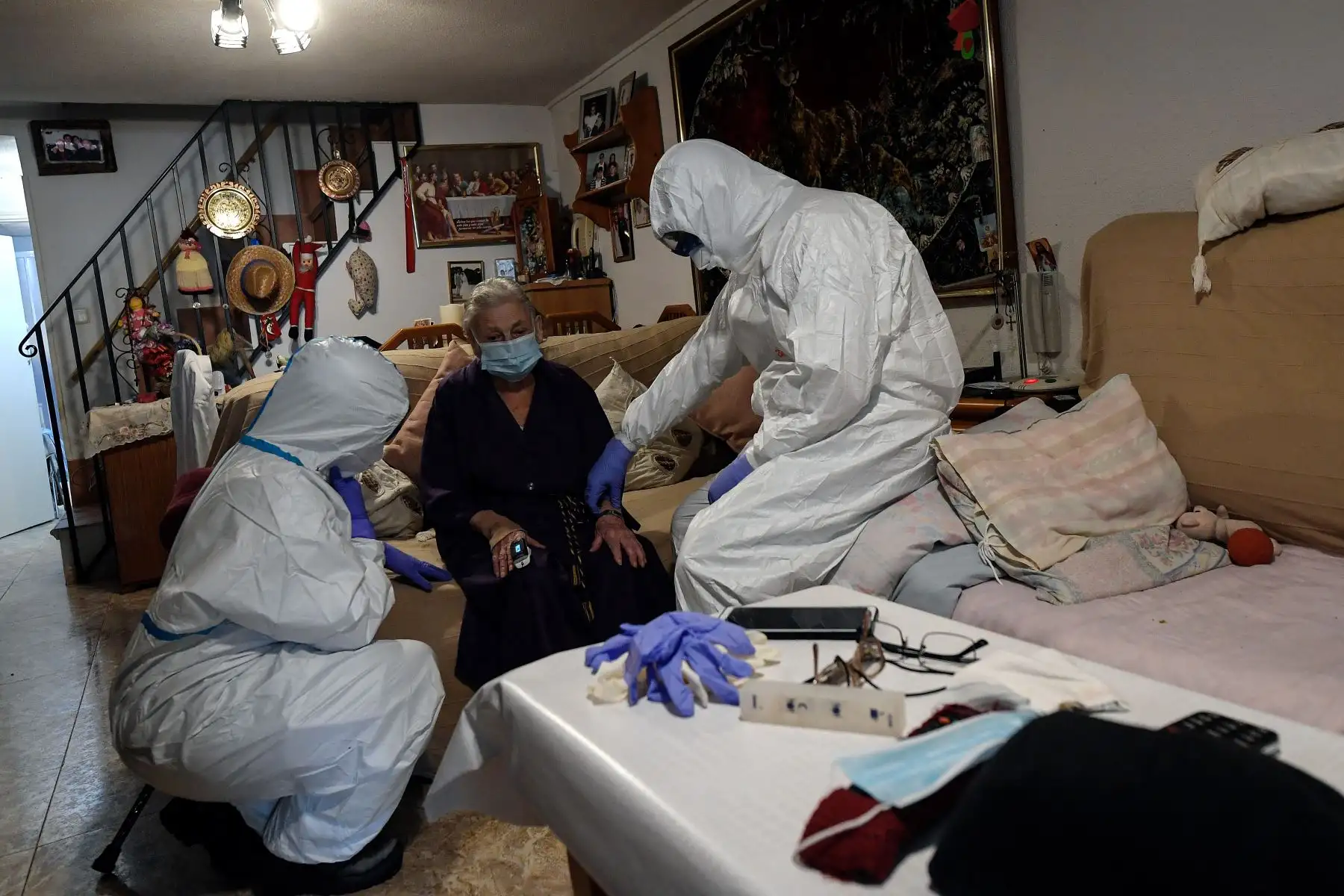 Trabajadores sanitarios de la unidad UVI-6 de los Servicios de Emergencias Médicas de Madrid examinan a una presunta paciente de COVID-19. Foto: AFP