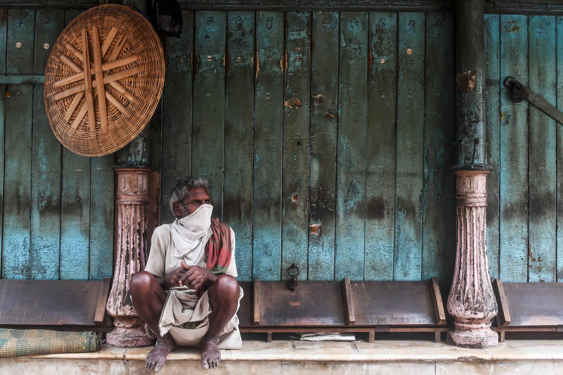 Un trabajador se sienta junto a las tiendas cerradas mientras espera el trabajo diario durante un bloqueo nacional impuesto por el gobierno como medida preventiva contra el coronavirus COVID-19, en Kolkata.FotoÑ AFP