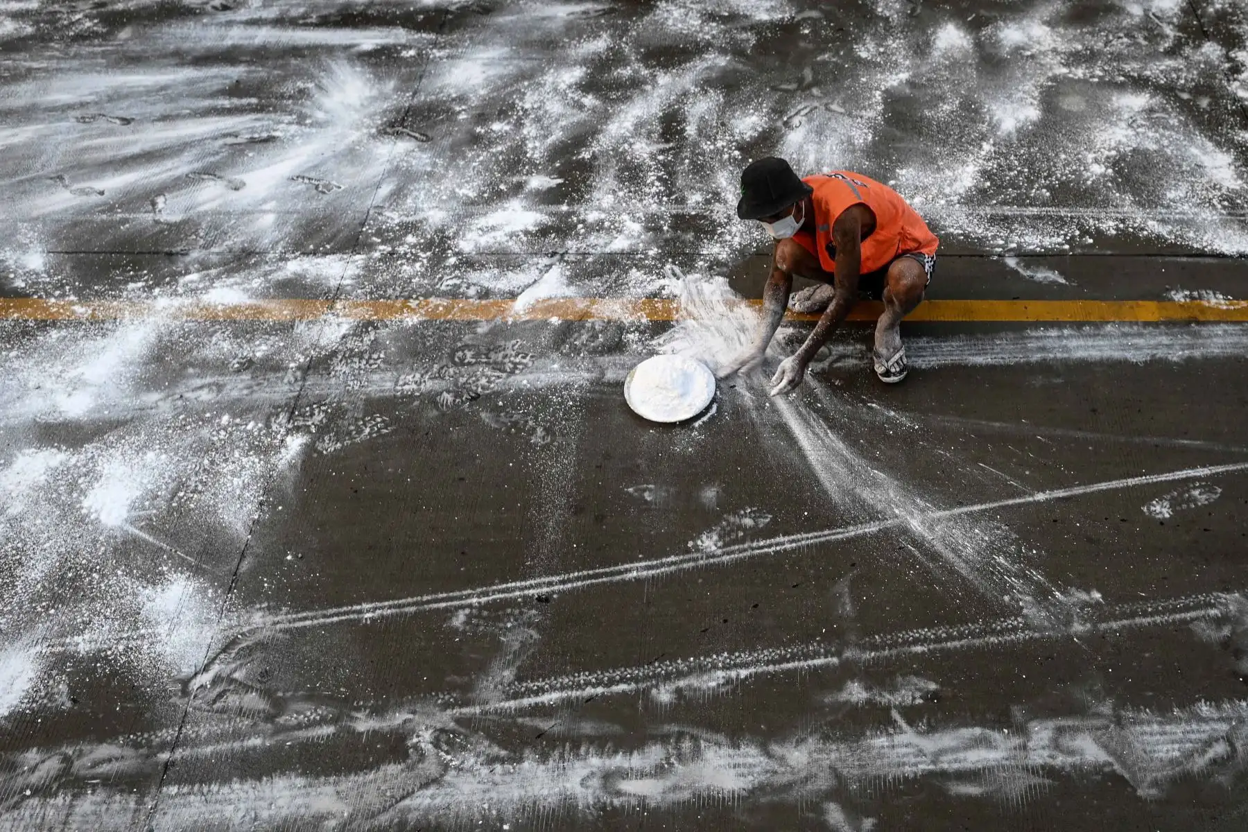 Los voluntarios esparcieron óxido de calcio en una carretera como medida preventiva contra la propagación del nuevo coronavirus COVID-19 en Yangon. Foto: AFP