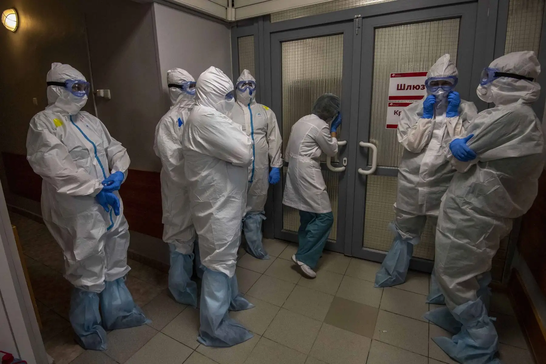 Trabajadores médicos que usan equipo de protección esperan frente a la puerta de entrada para ingresar a la zona roja para tratar a los pacientes con coronavirus en el hospital clínico Spasokukotsky en Moscú. Foto: AFP