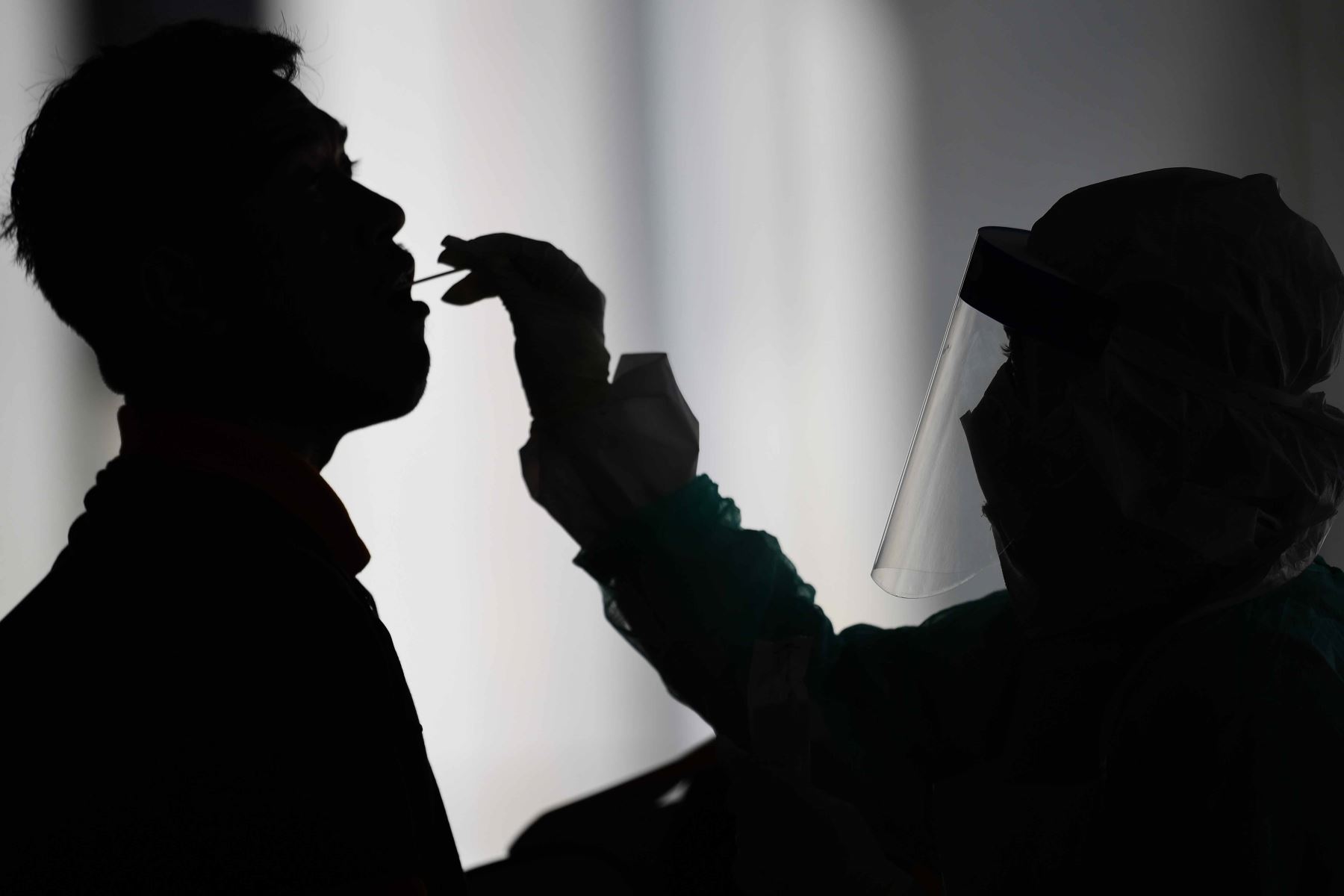 Un trabajador de salud usa un hisopo para recolectar una muestra para la prueba de coronavirus COVID-19 de un hombre en Gombak en las afueras de Kuala Lumpur. Foto: AFP