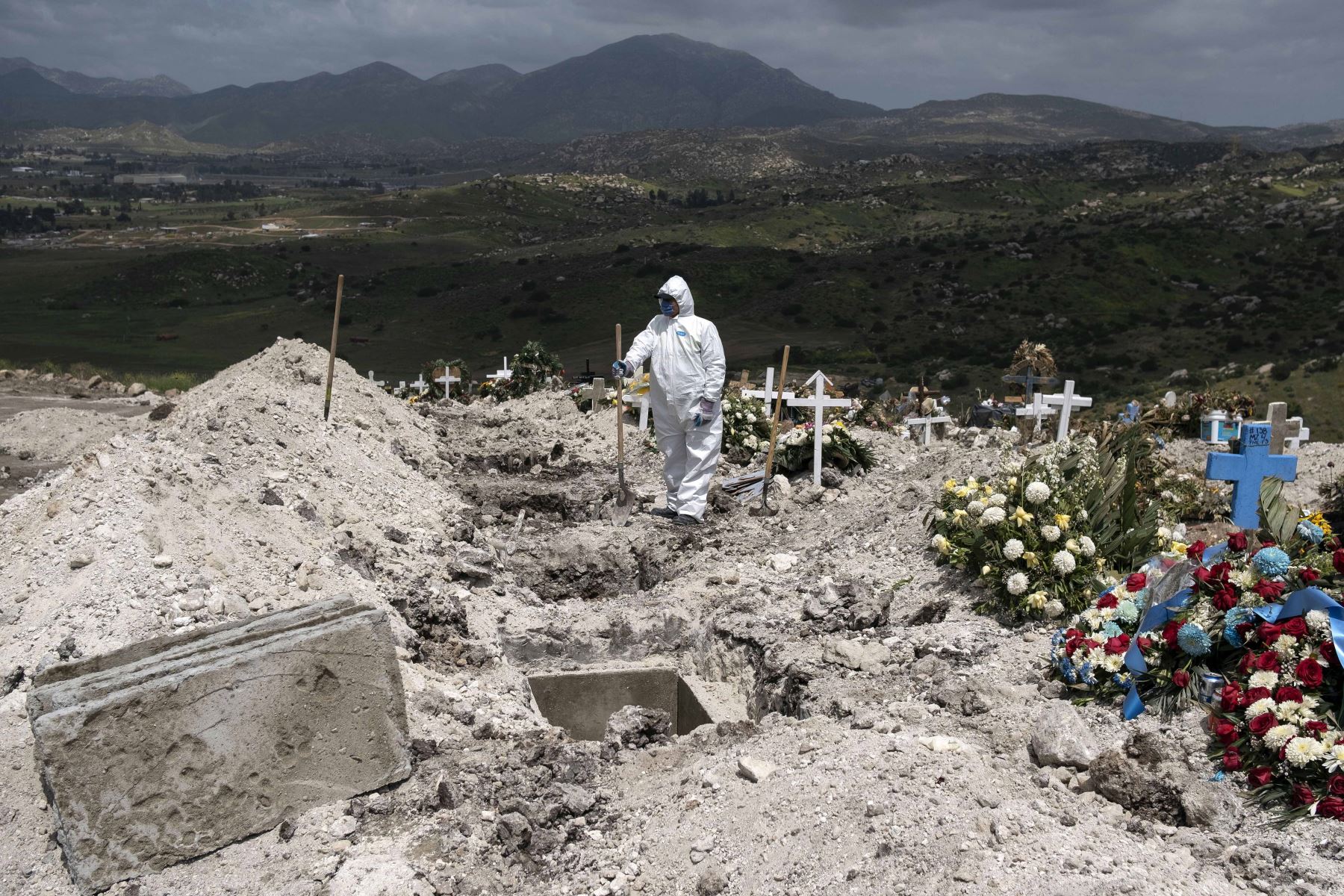 Un trabajador del cementerio con equipo de protección espera a una víctima de coronavirus COVID-19 no reclamada, en el cementerio municipal No. 13 en Tijuana, estado de Baja California, México. Foto: AFP