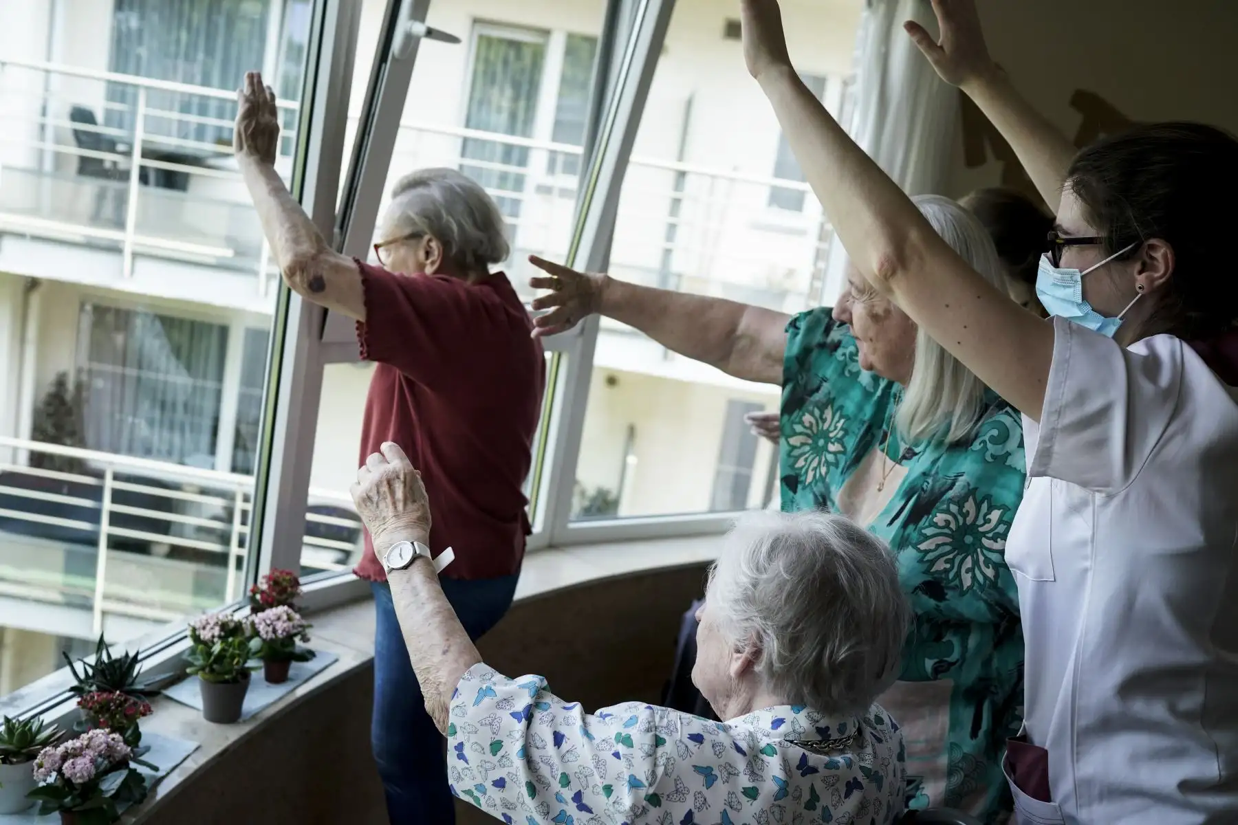 Los miembros del personal y los residentes saludan a sus familias en la residencia de ancianos Christalain, en Bruselas, durante un estricto encierro en el país para luchar contra el nuevo coronavirus. Foto: AFP