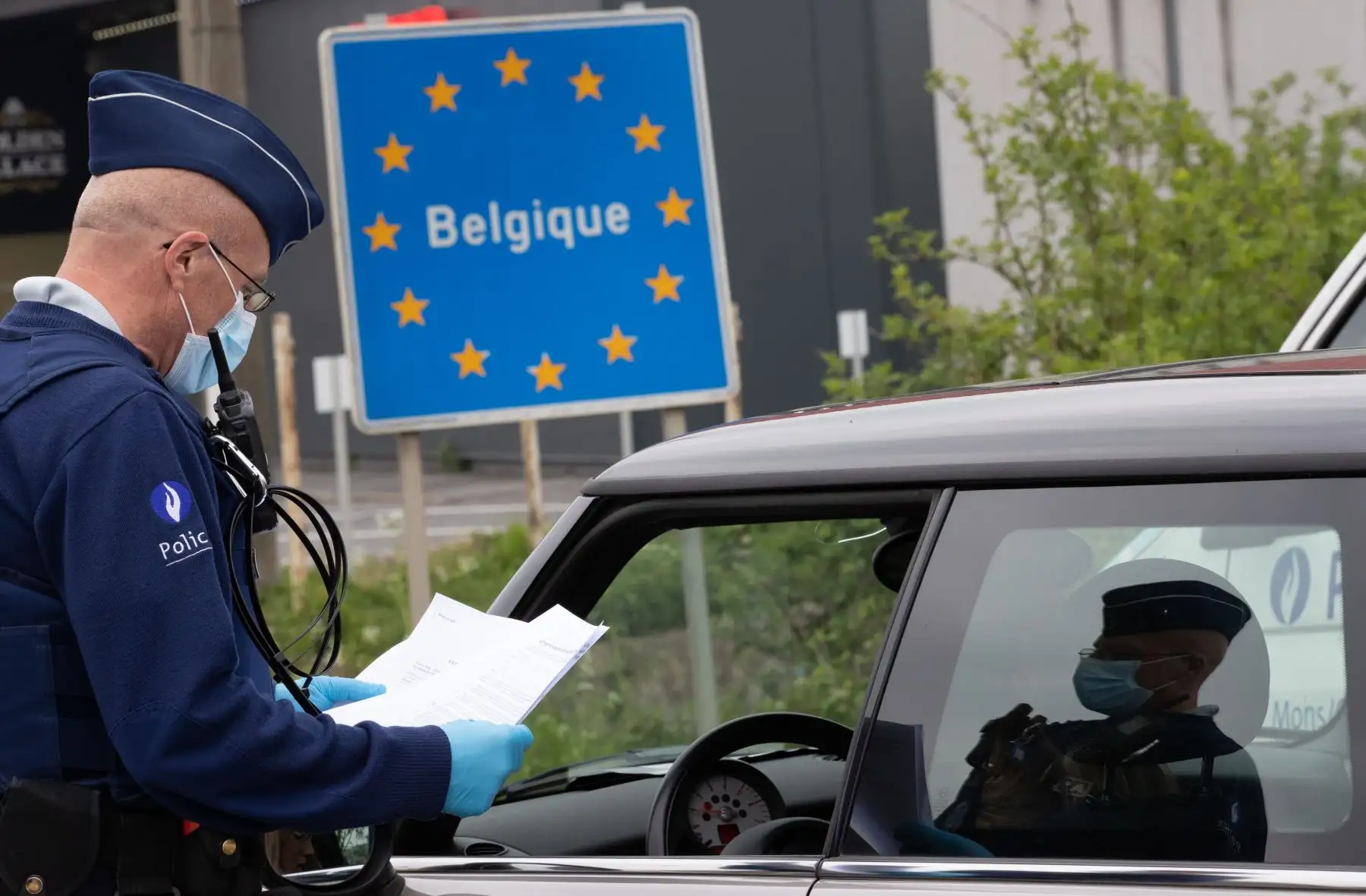 Un oficial de policía belga controla los documentos de una persona en un automóvil en la frontera entre Bélgica y Francia durante una patrulla policial en Quevy, haciendo cumplir las reglas de distanciamiento social. Foto: AFP