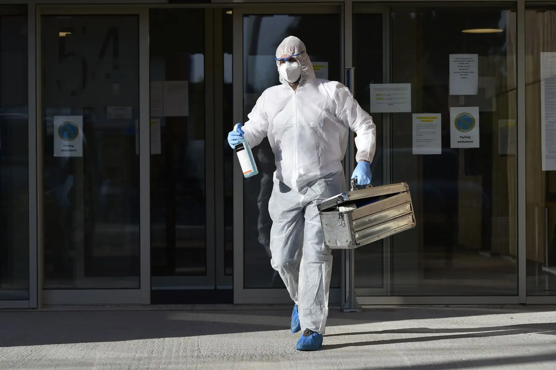 Un empleado de la funeraria Chaudoir que usa un equipo de protección abandona la residencia Saint-Joseph después de que una persona murió del COVID-19. Foto: AFP