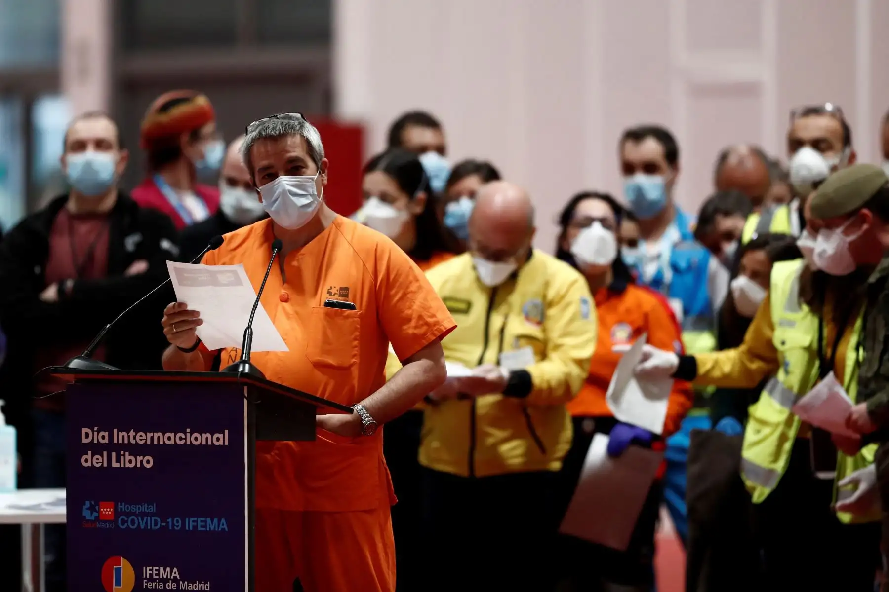 Varios profesionales de distintos ámbitos esperan para leer un pasaje de El Quijote en el hospital de campaña provisional instalado en Ifema por el  Día del libro. 
Foto: EFE