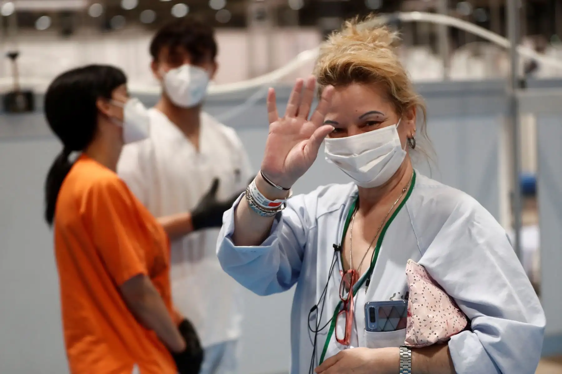 Una paciente saluda en el hospital de campaña provisional instalado en Ifema . Por el Día del libro las personas que trabajan allí y los enfermos leen El Quijote y se regalan rosas y claveles.
Foto: EFE