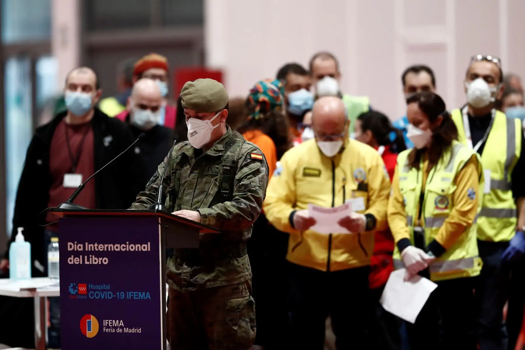 Varios profesionales de distintos ámbitos esperan  leer un pasaje de El Quijote en el hospital de campaña provisional instalado en Ifema por el Día del libro.
Foto: EFE
