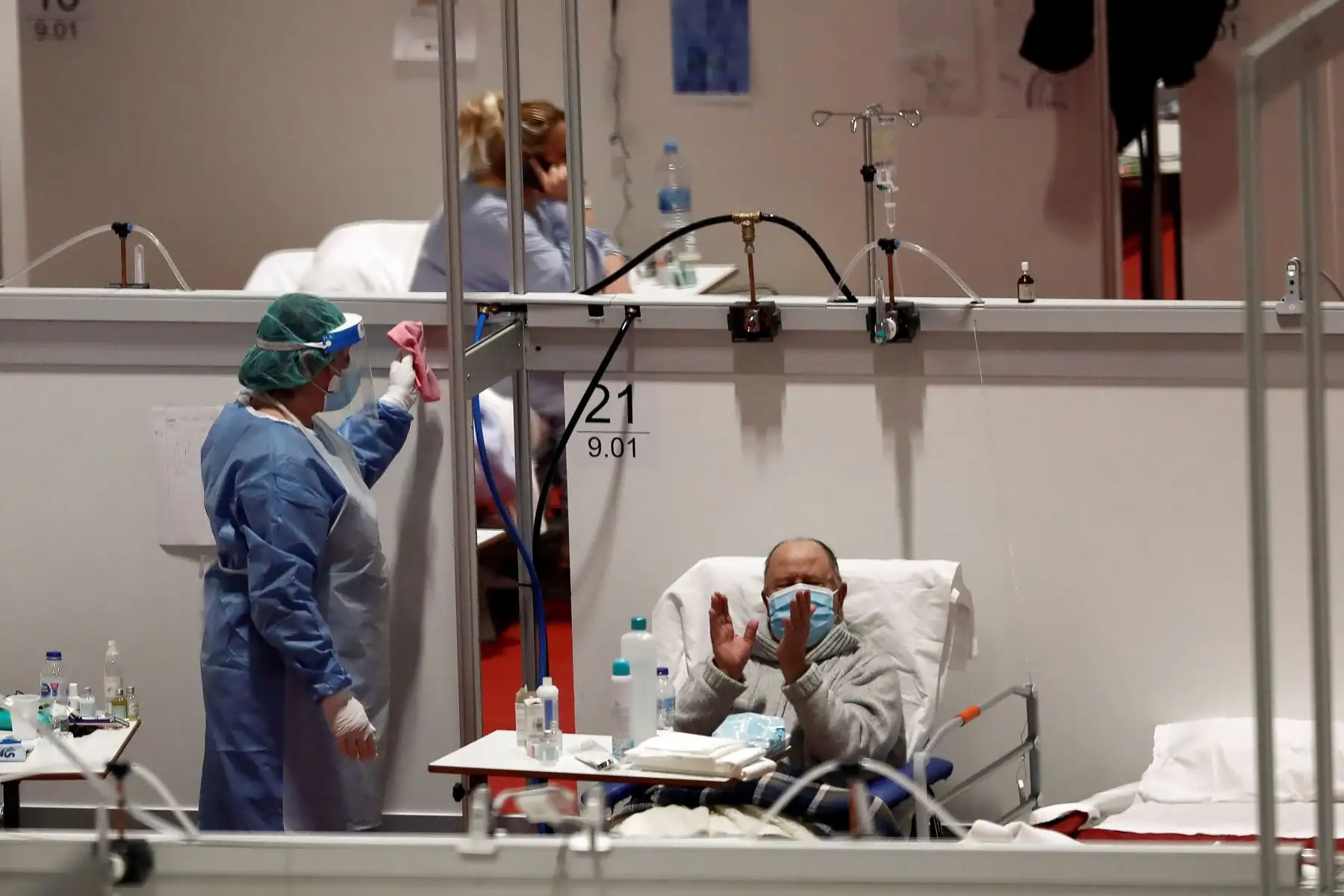Un paciente del hospital de campaña provisional instalado en Ifema aplaude la lectura del Quijote por el  Día del Libro.
Foto: EFE