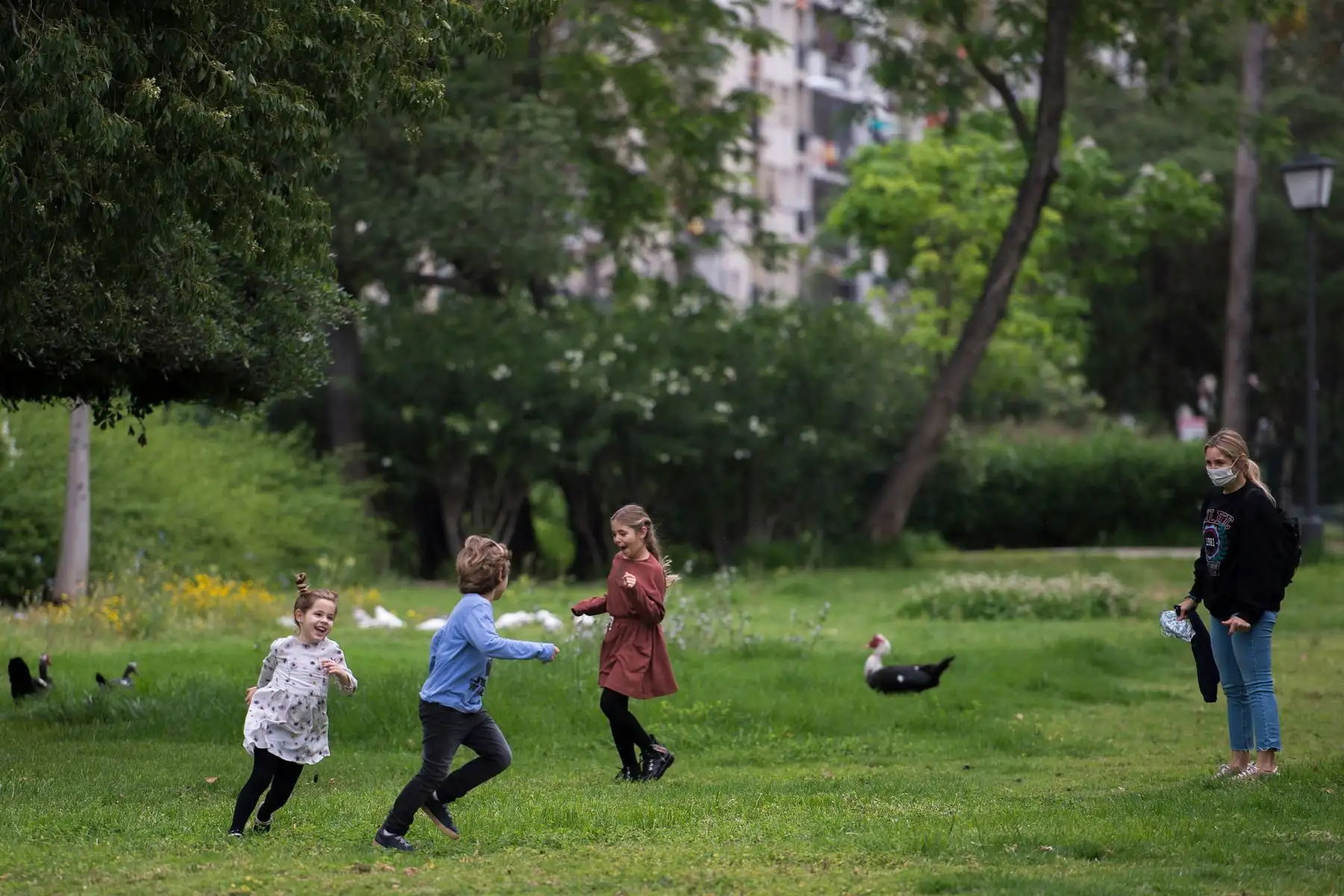 Niños juegan bajo supervisión de su madre en medio de un cierre nacional para evitar propagación de coronavirus, en Sevilla. Foto: AFP