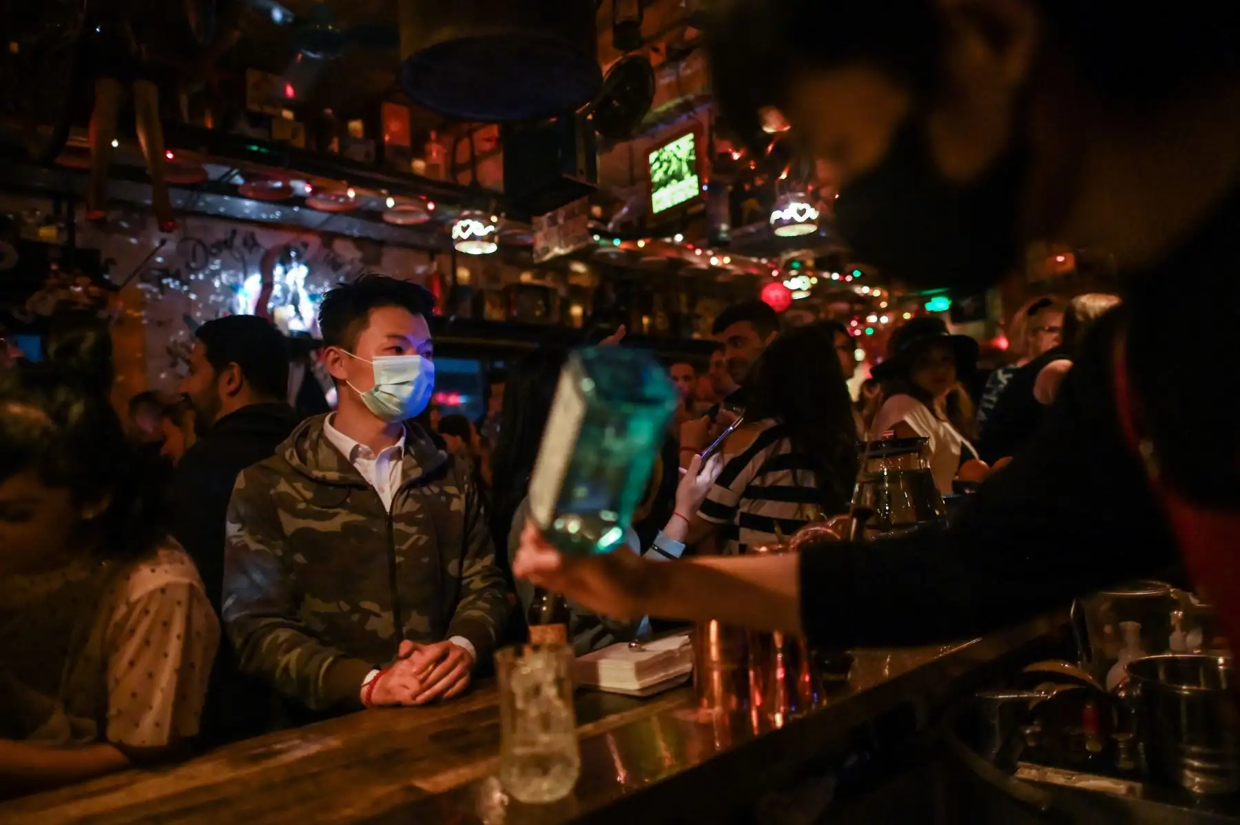 Un hombre con una máscara facial como medida preventiva contra el coronavirus acude a una discoteca, en Shanghai. Foto: AFP