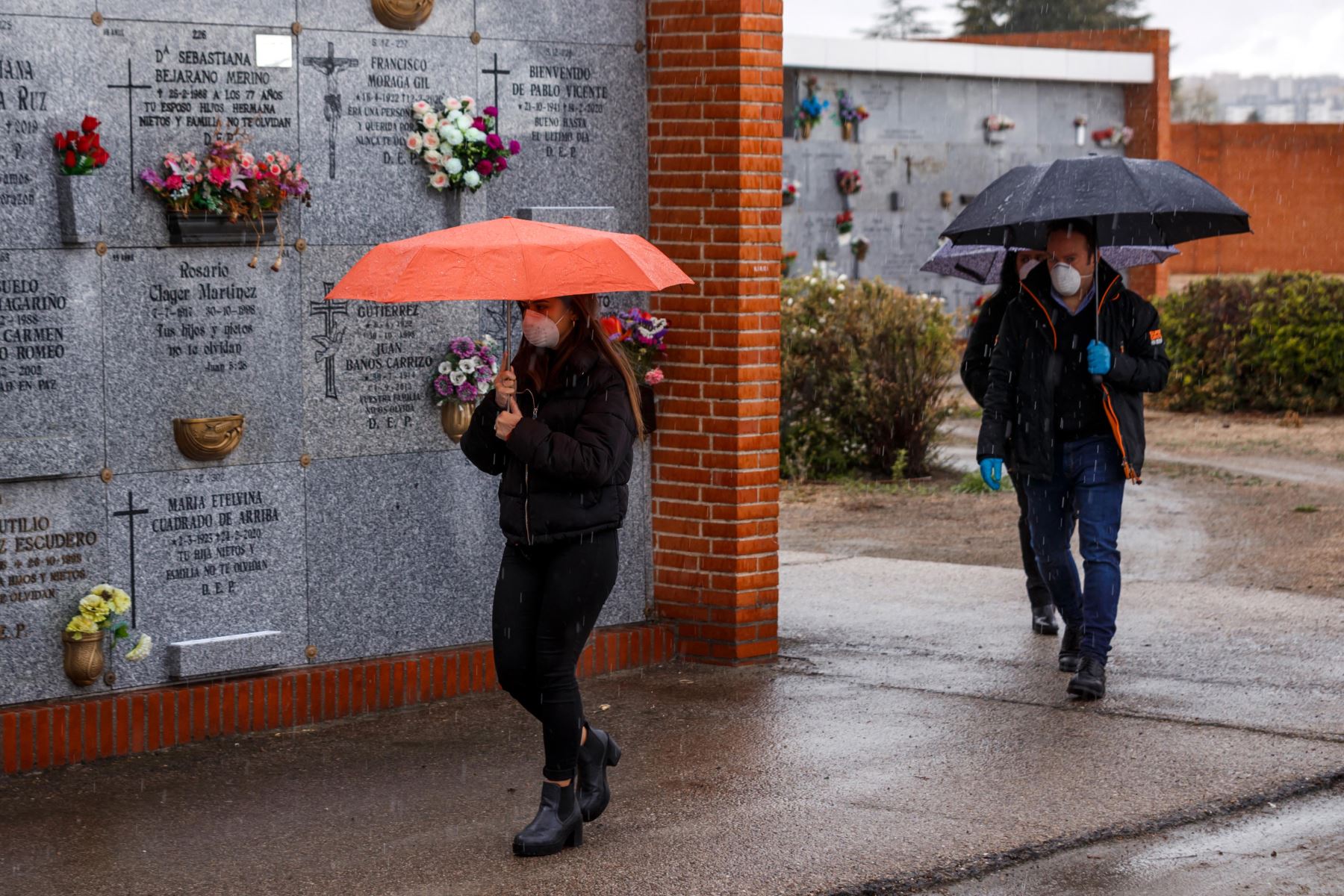 Personas con máscaras faciales llegan al cementerio municipal del sur de Madrid para asistir al entierro de un hombre que murió por el nuevo coronavirus. Foto: AFP