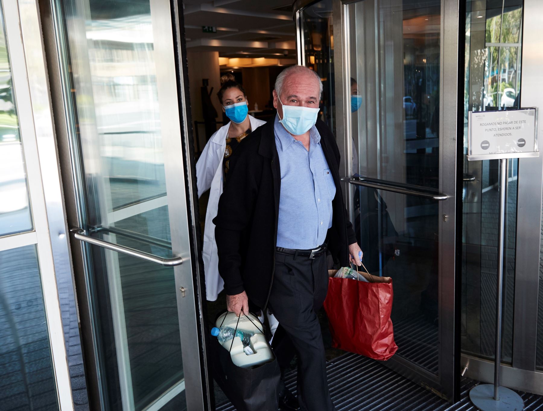 Un paciente sale por la puerta tras recibir el alta en el hotel Sarria de Barcelona, que aloja 150 pacientes que están en cuarentena después de pasar por hospitales y centros de salud de la zona.  Foto: EFE