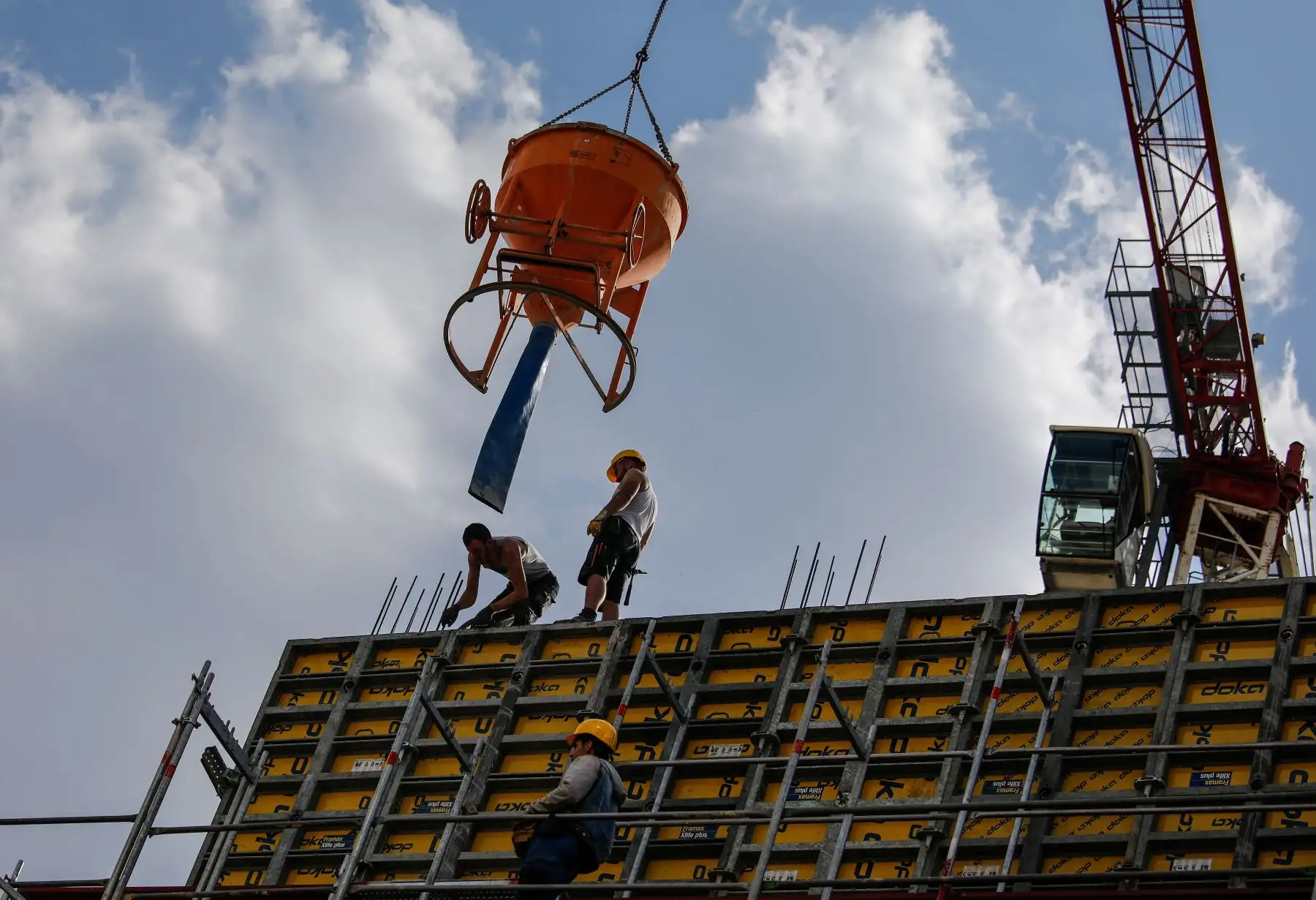 Un grupo de trabajadores vierten concreto en una obra de construcción en el distrito de Kreuzberg de Berlín, en medio de la nueva pandemia de coronavirus COVID-19. Foto: AFP