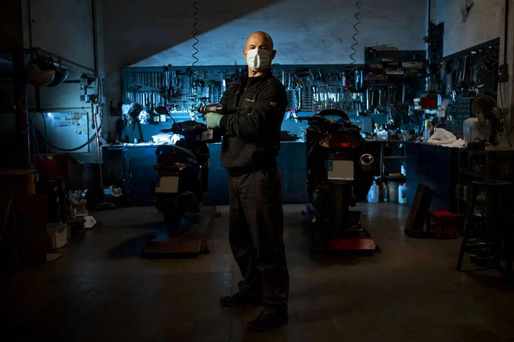 Un mecánico de motocicletas, posa en su taller en Barcelona, España, el 22 de abril de 2020 durante la pandemia de coronavirus COVID-19. Foto: AFP