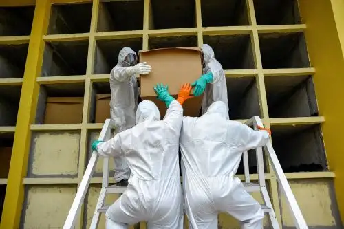 Trabajadores del cementerio Parques de la Paz meten una caja de cartón con un fallecido por covid-19 en un nicho, en el sector de la Aurora, Guayas (Ecuador). Foto: Efe.