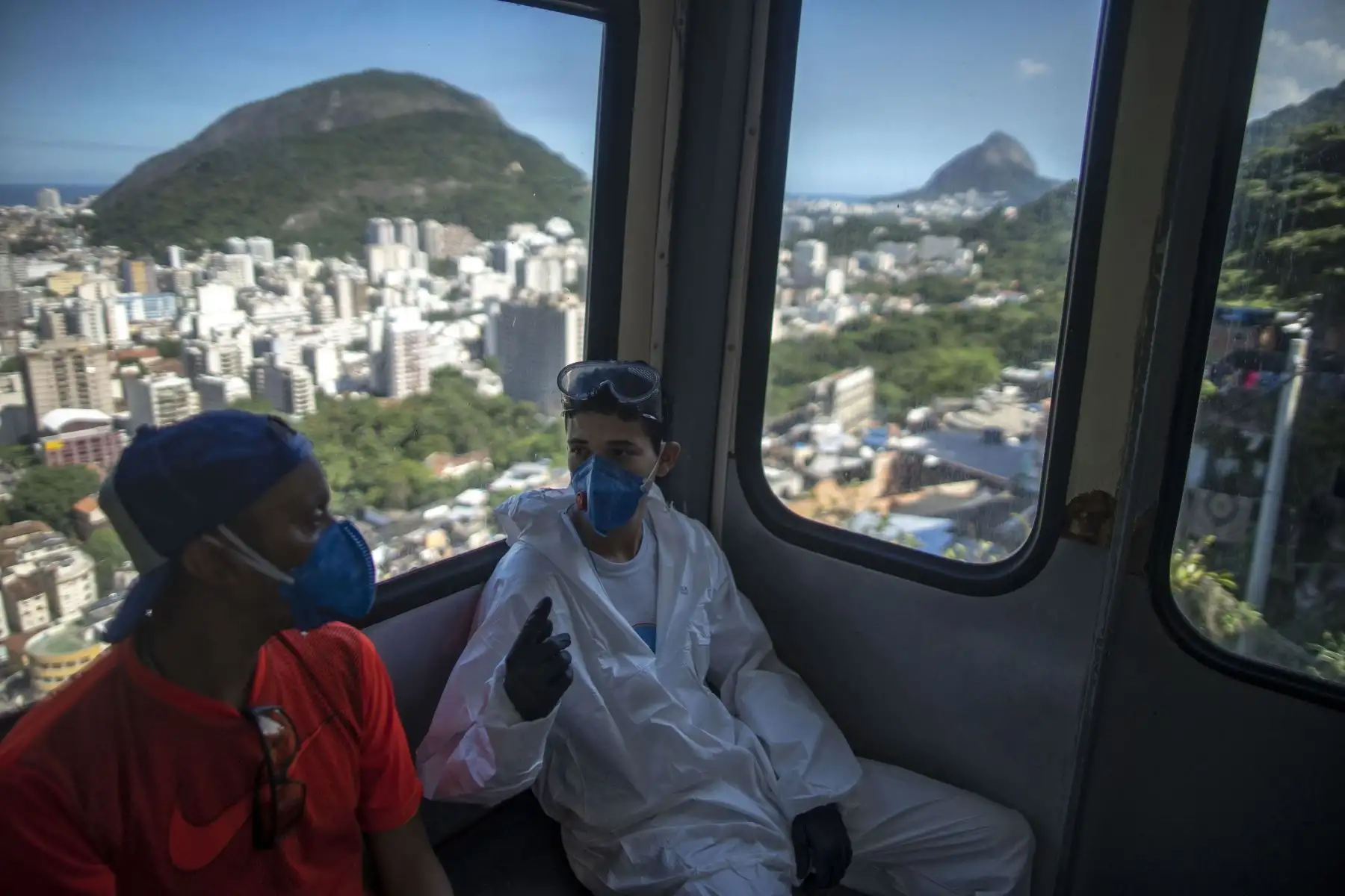 Voluntarios que desinfectan la favela de Santa Marta en Río de Janeiro, Brasil, durante la pandemia de coronavirus COVID-19 toman el elevador el 20 de abril de 2020. Foto: AFP