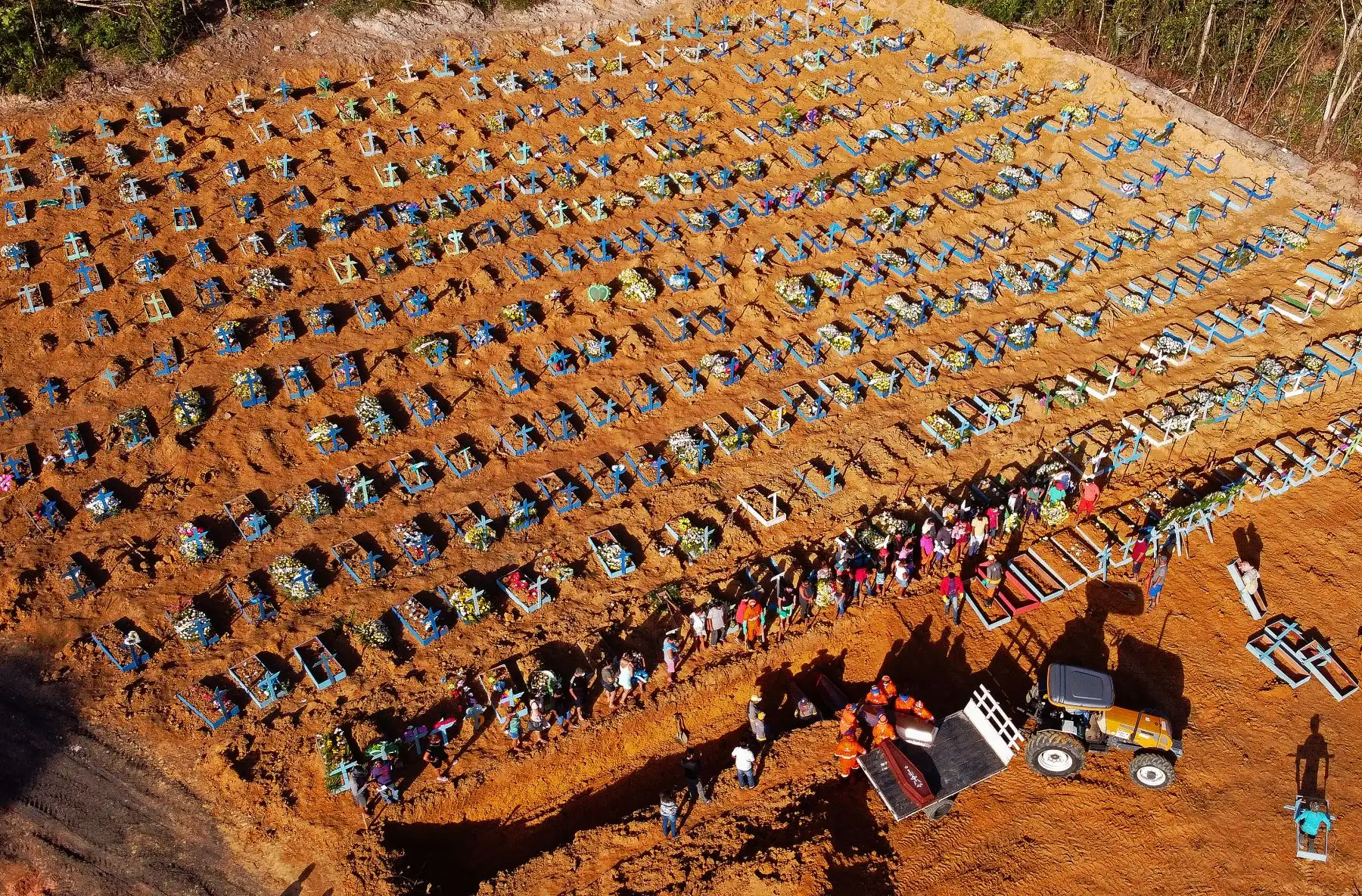 Vista aérea de los trabajadores del cementerio descargando un ataúd de un camión en un área donde se han excavado nuevas tumbas en el cementerio Parque Taruma, durante la pandemia de coronavirus COVID-19 en Manaos. Foto: AFP