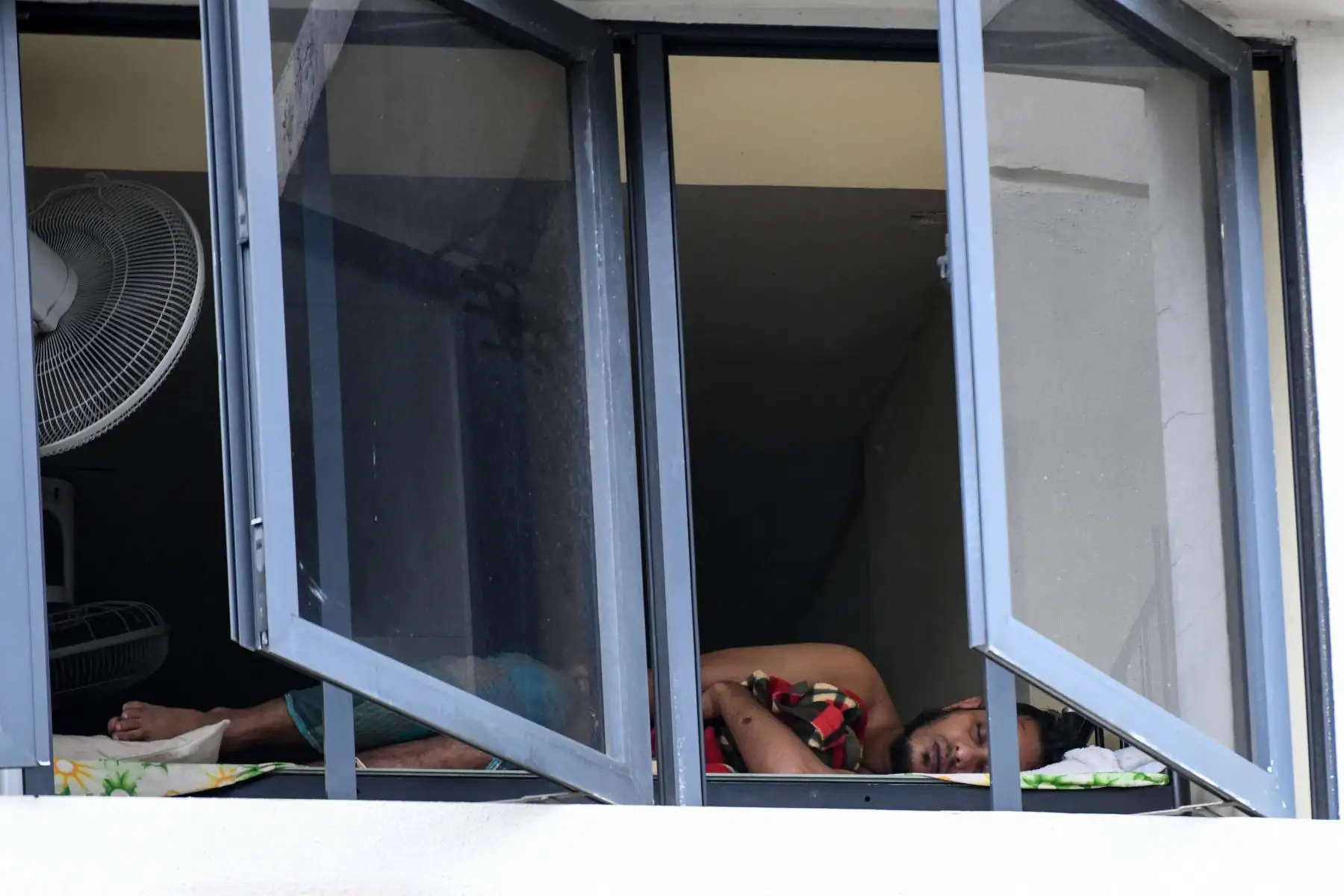 Un trabajador migrante duerme en una habitación en el domicilio de un trabajador extranjero, actualmente bajo aislamiento como medida preventiva contra la propagación del nuevo coronavirus COVID-19. Foto: AFP
