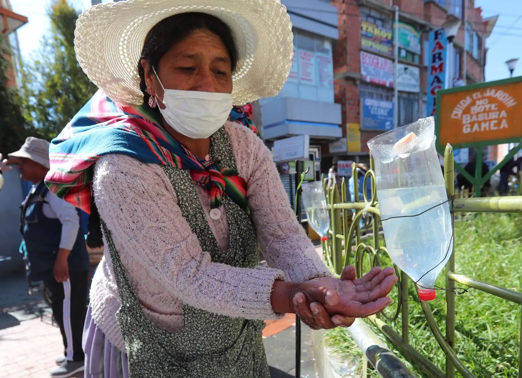 Una mujer aimara se lava las manos antes de ingresar a una cámara de medicina tradicional, donde usan plantas de eucalipto, manzanilla y huira huira, que tienen cualidades "expectorantes" y que ayudan a las vías respiratorias. Foto: EFE