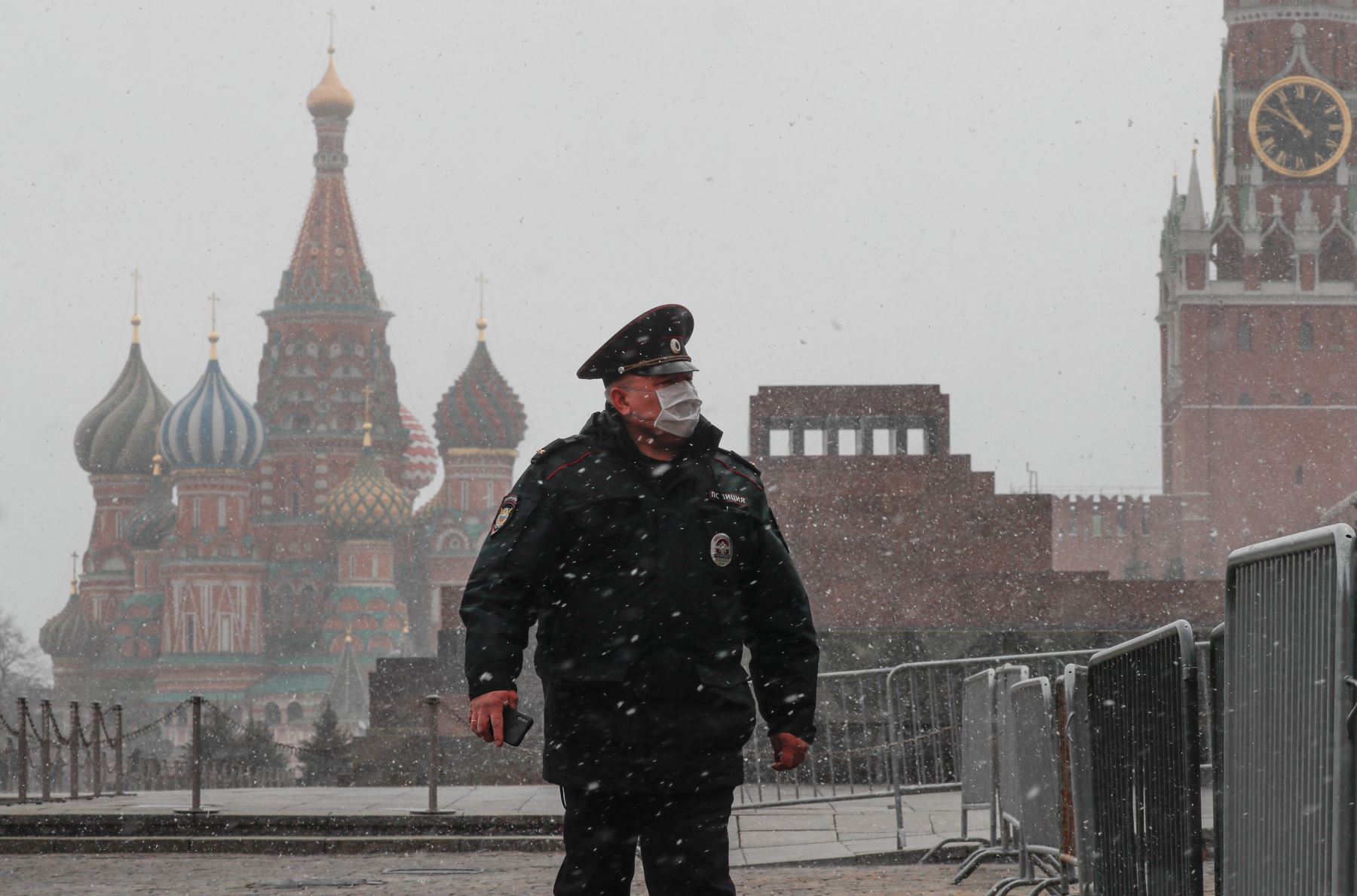 Un policía con máscaras protectoras camina por la Plaza Roja frente al Kremlin en Moscú, Rusia. Foto: EFE