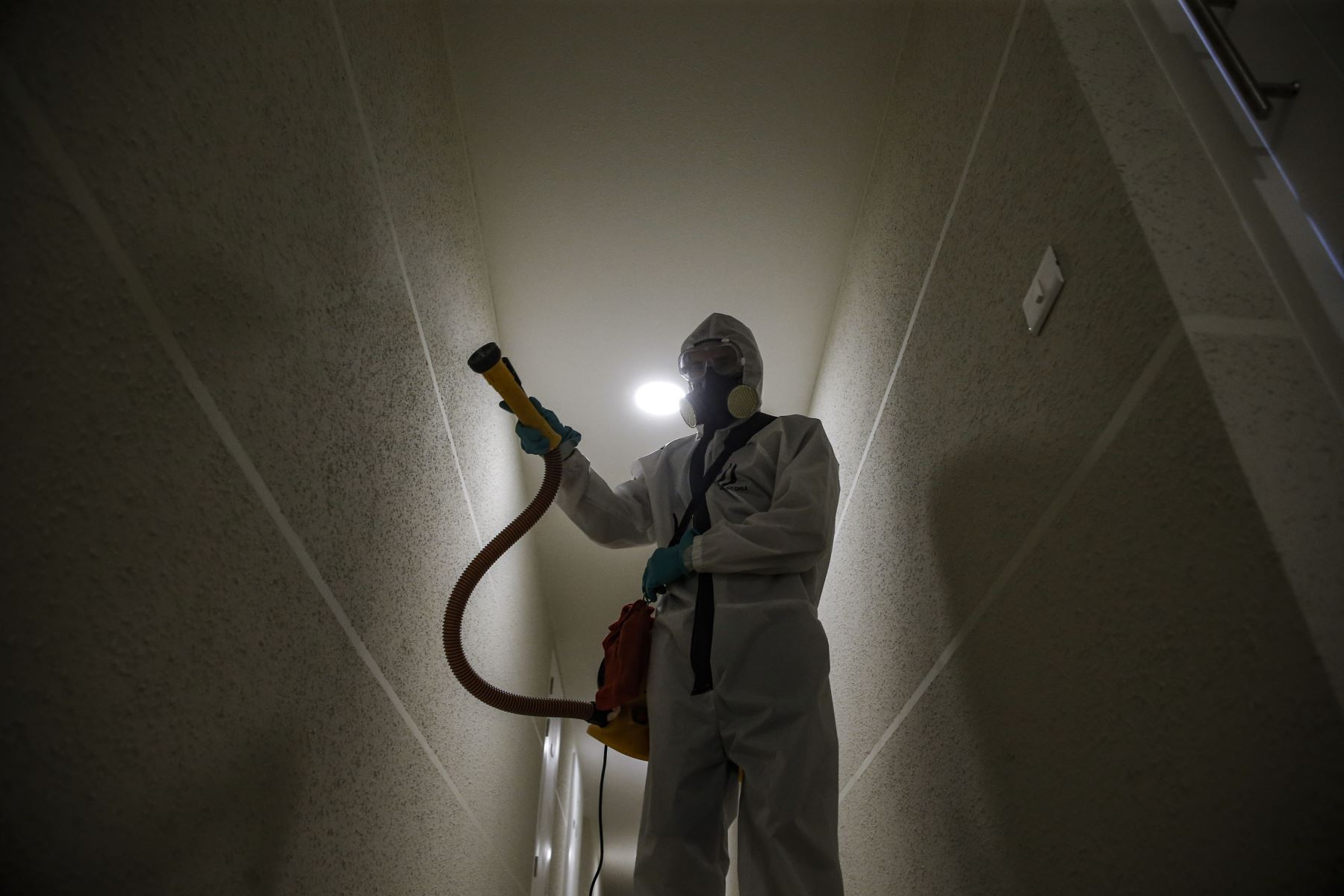 Un trabajador de saneamiento desinfecta un edificio comunitario como medida preventiva contra la propagación del nuevo coronavirus COVID-19 en Santiago de Chile. Foto: AFP
