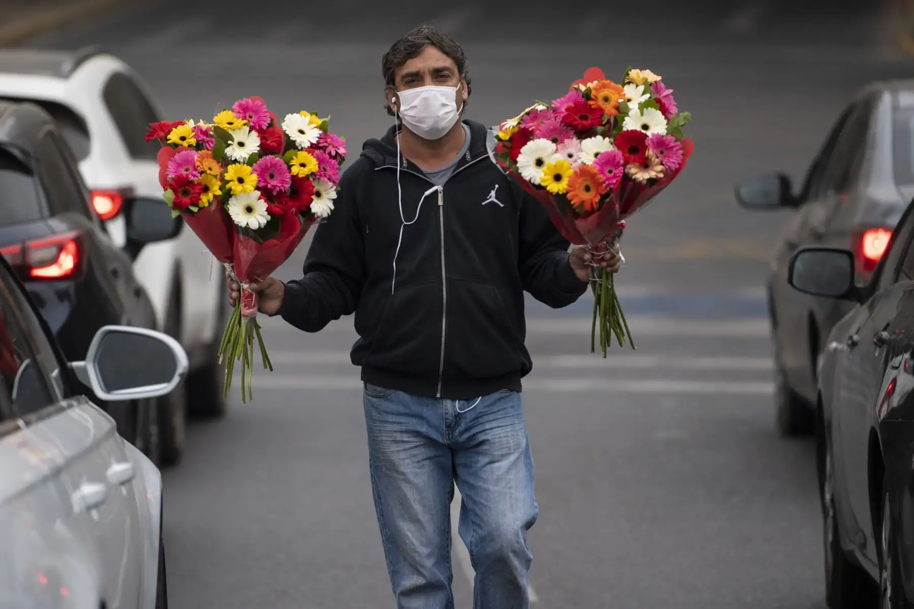 Un vendedor informal vende flores en un semáforo en Santiago. Foto: AFP