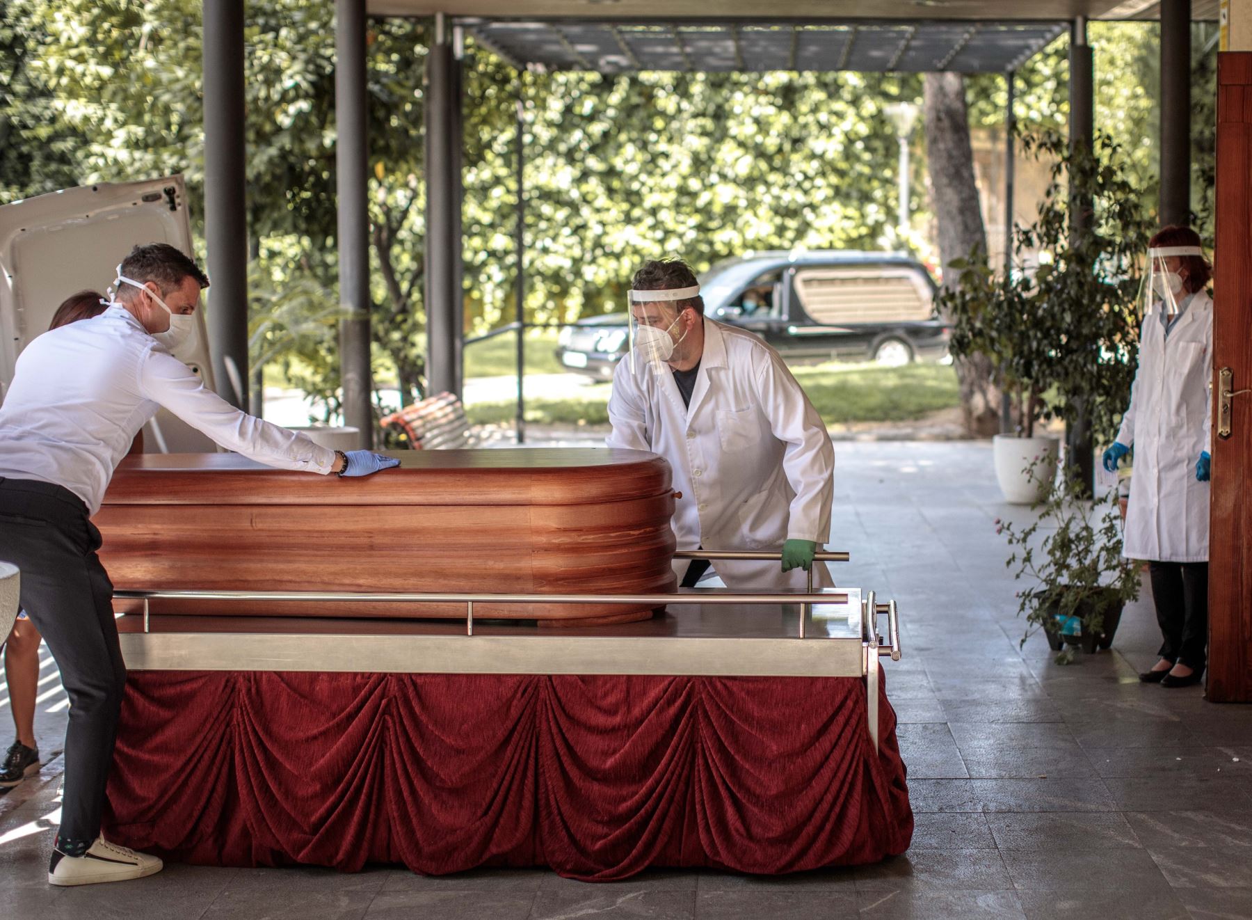 Operarios del cementerio municipal de València y miembros de una funeraria introducen un féretro en la sala de ceremonias del crematorio que permanece cerrada a familiares de la víctima. Foto: EFE