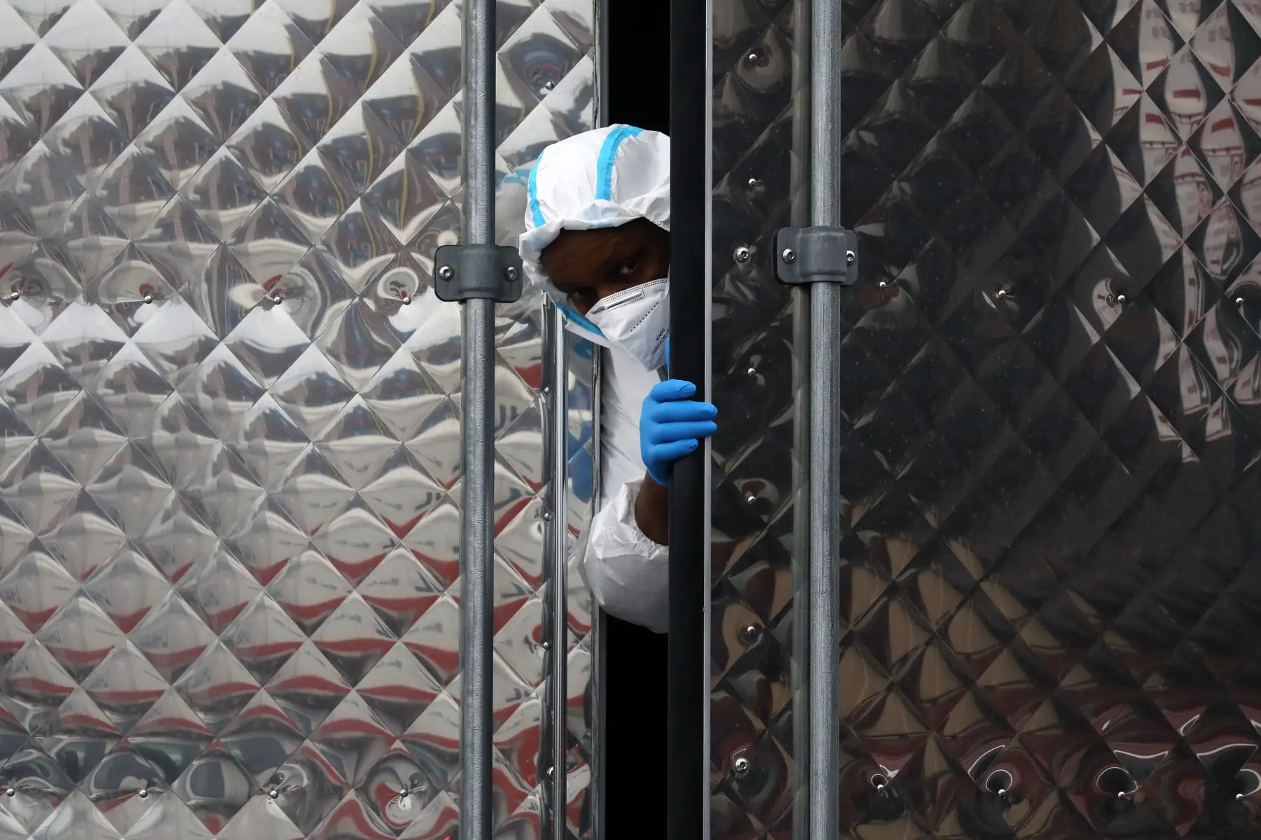 Un hombre asoma la cabeza de un camión con docenas de cuerpos afuera de la funeraria Andrew Cleckley en el barrio de Brooklyn de la ciudad de Nueva York. Foto: AFP
