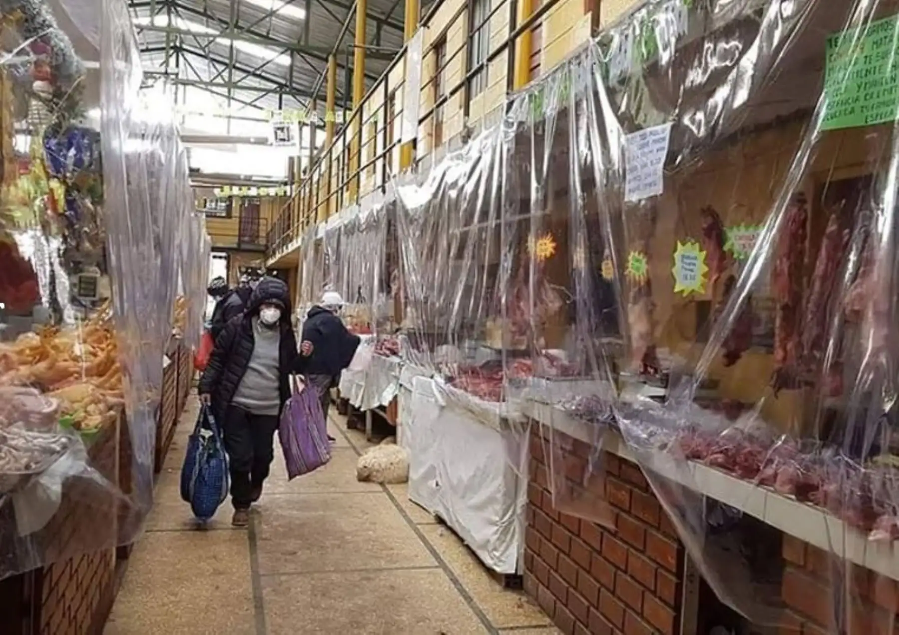 Comerciantes de mercados del distrito de Yanacancha, provincia de Pasco, refuerzan con plástico su protección para evitar ser contagiados con coronavirus. Foto: Entre Voces/Facebook