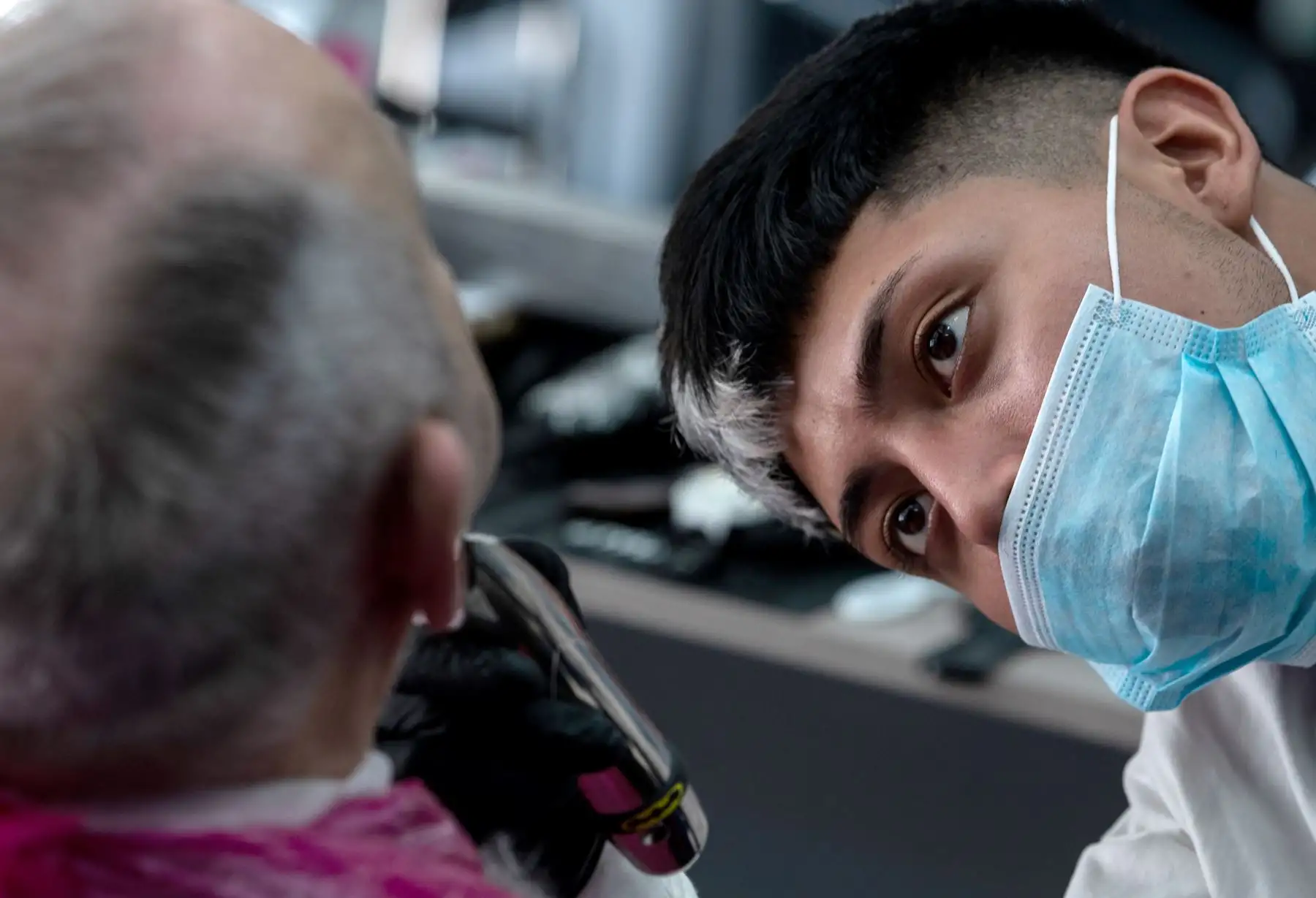 Un barbero atiende a un cliente en Valencia el 4 de mayo de 2020 después de reabrir su barbería por primera vez desde el inicio de un cierre nacional para evitar la propagación de la enfermedad COVID-19. Foto: AFP