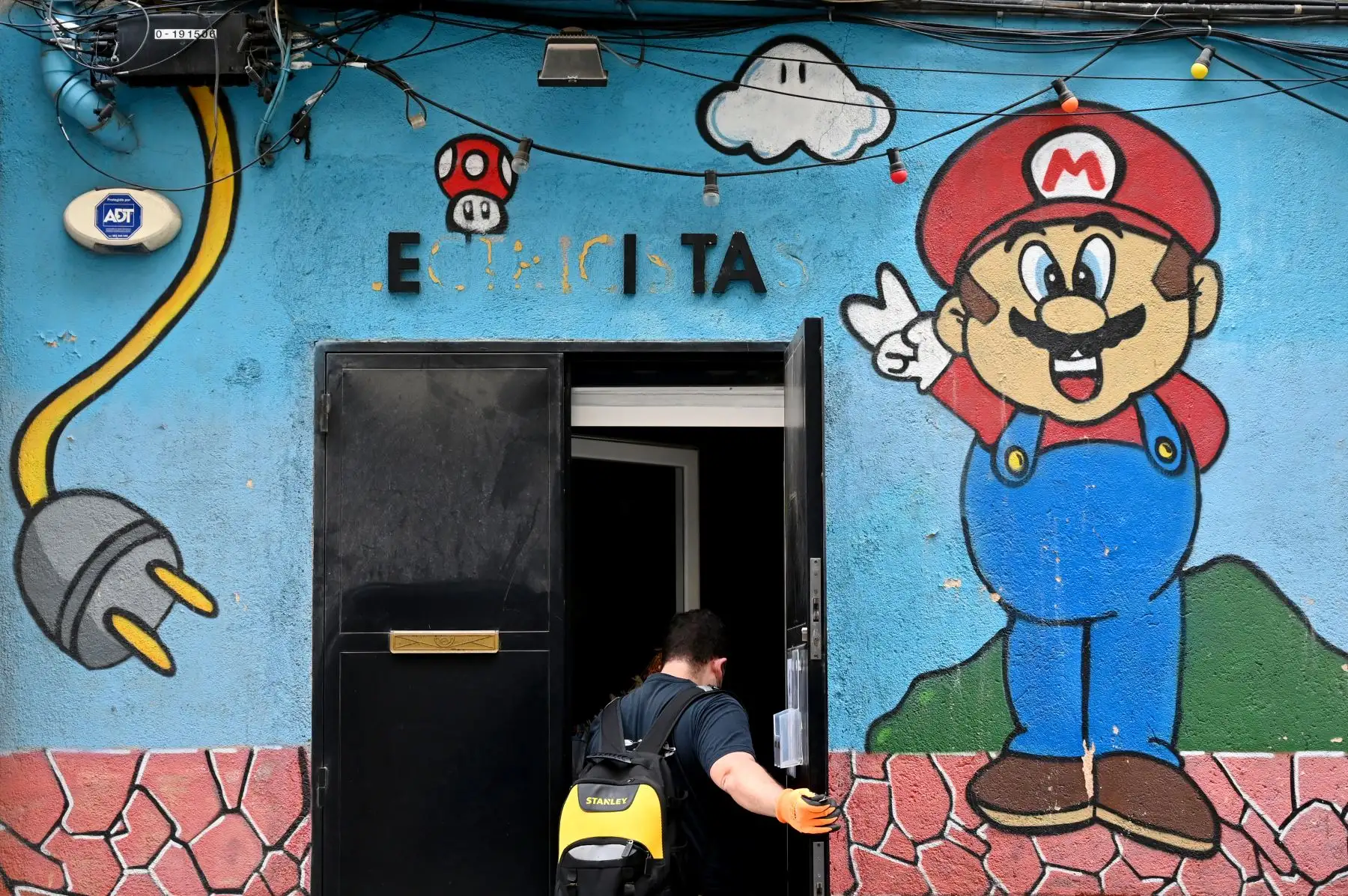 Un hombre abre su tienda de suministros eléctricos en Madrid, el 4 de mayo de 2020, por primera vez desde el inicio de un bloqueo nacional para prevenir la propagación de la enfermedad COVID-19. Foto: AFP