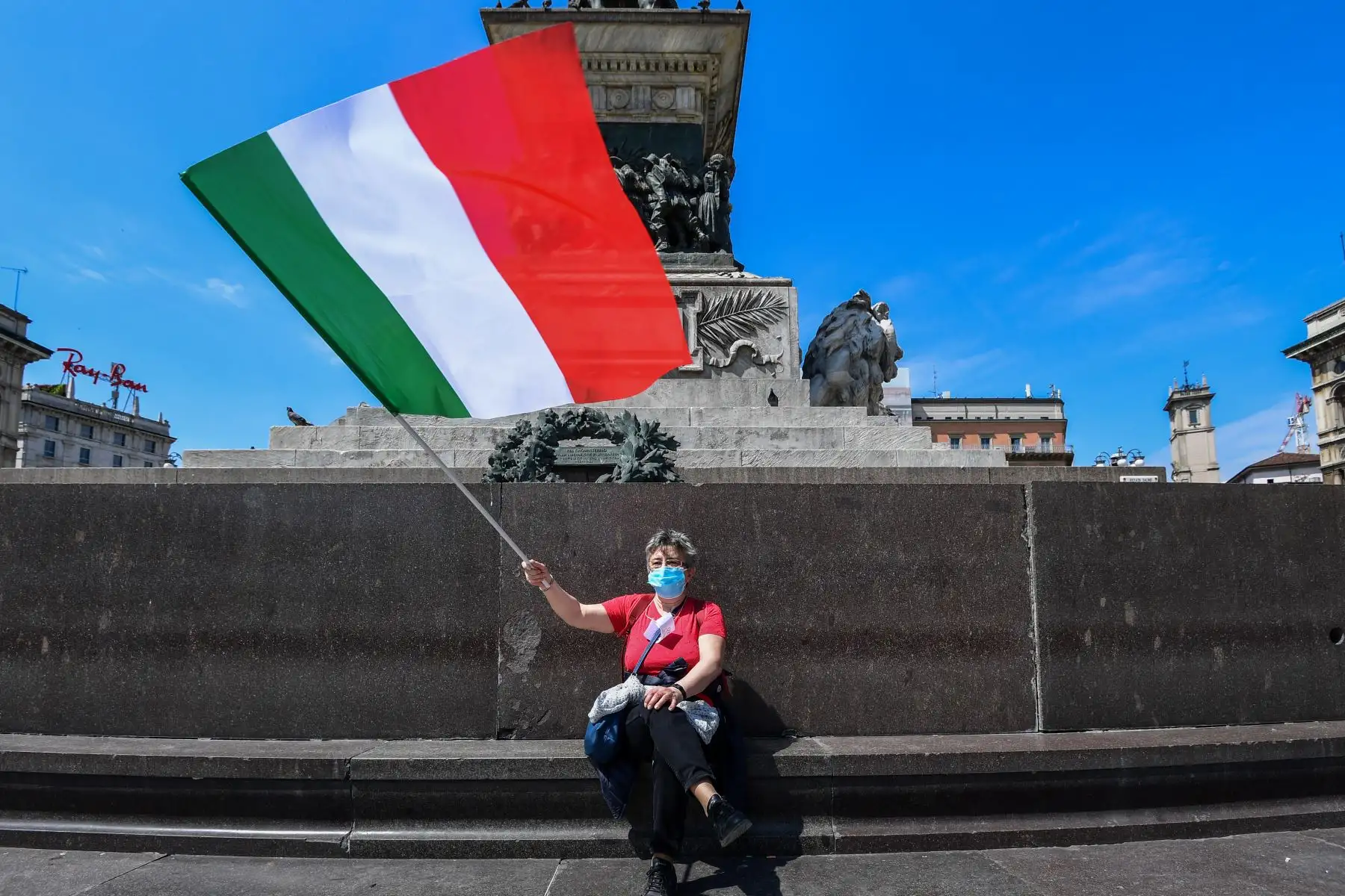 Una mujer ondea la bandera italiana el 4 de mayo de 2020 en Milán. Foto: AFP