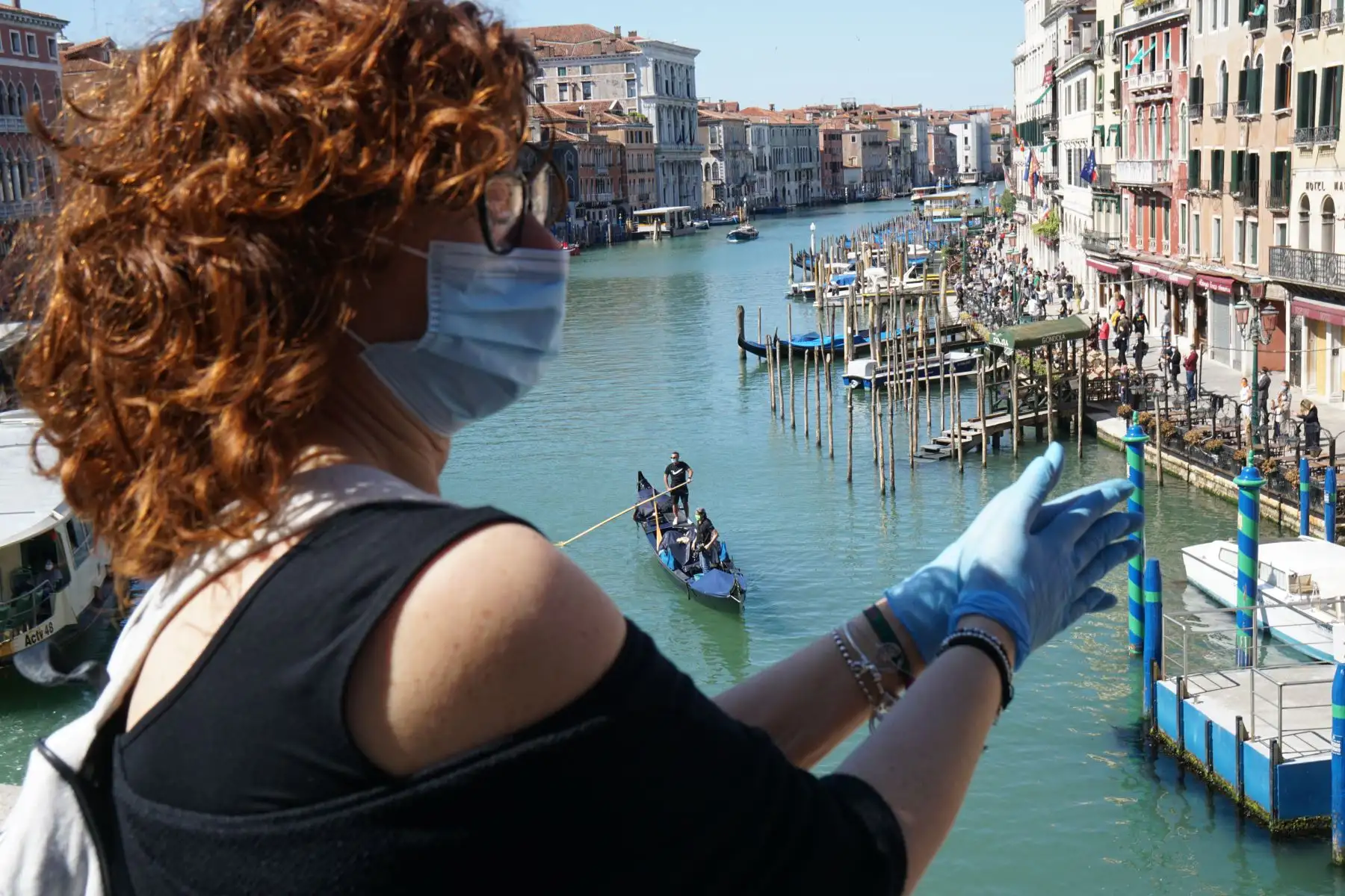 Una mujer participa en una protesta flashmob de los comerciantes que piden la reapertura de tiendas y actividades comerciales, el 4 de mayo de 2020 en el Puente de Rialto con vista al Gran Canal de Venecia. Foto: AFP