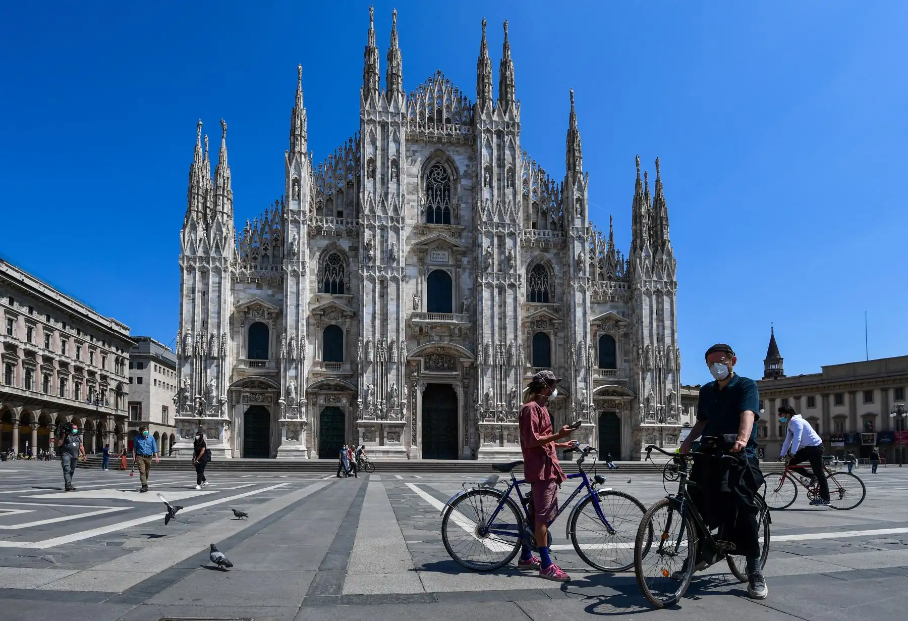 La gente monta su bicicleta y pasea por la Piazza del Duomo el 4 de mayo de 2020 en Milán. Foto: AFP