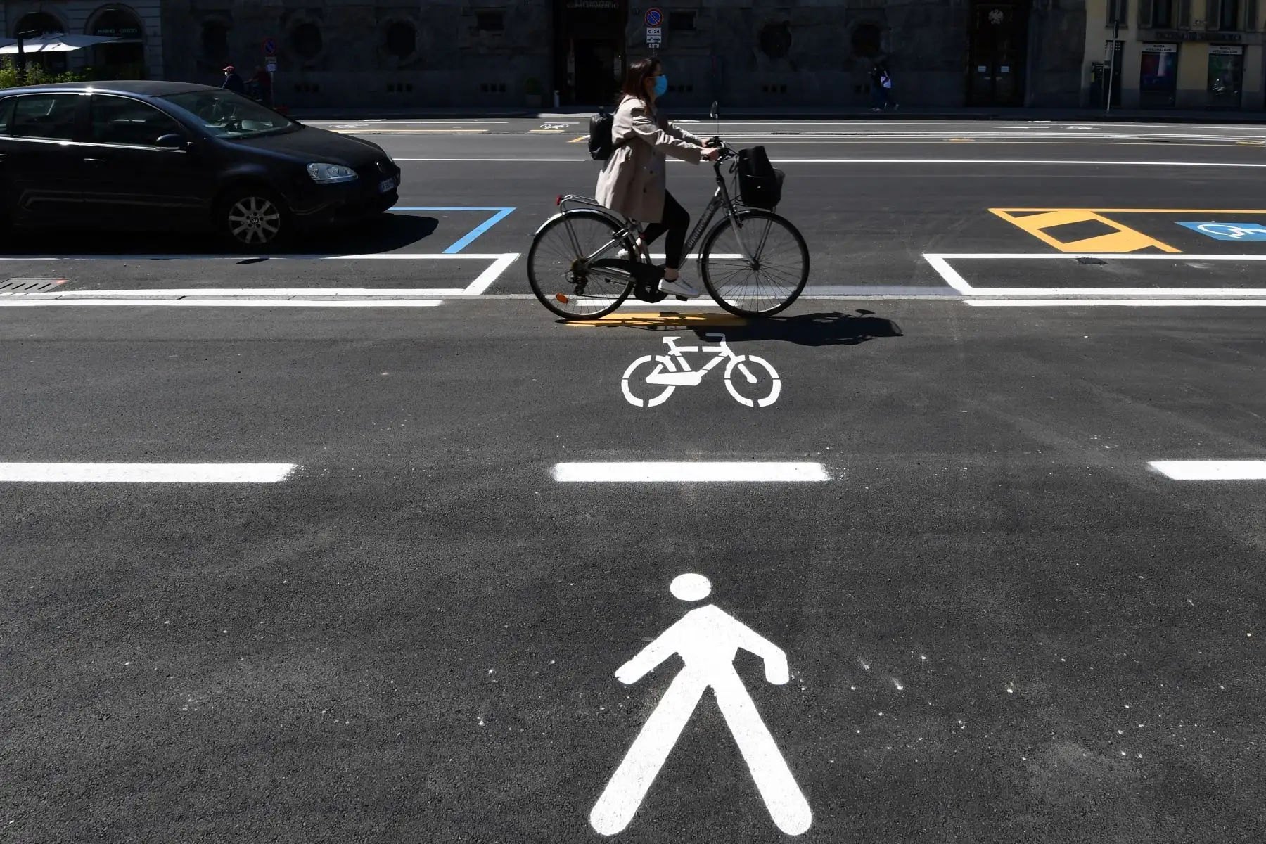 Una mujer monta una bicicleta en un carril bici en el centro de Milán. Foto: AFP