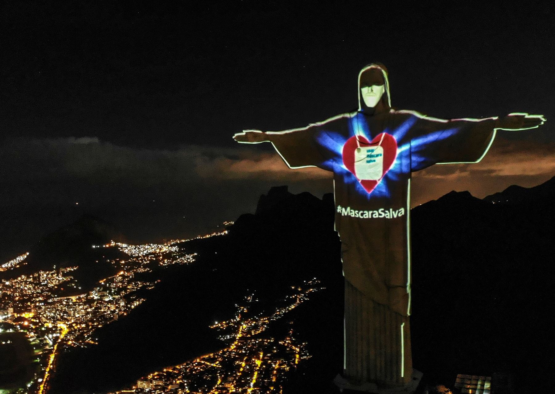 El Cristo Redentor de Río de Janeiro luce una máscara proyectada en su rostro para concienciar a la población de la importancia de su uso durante la pandemia de coronavirus este domingo, en Río de Janeiro (Brasil). Foto: EFE