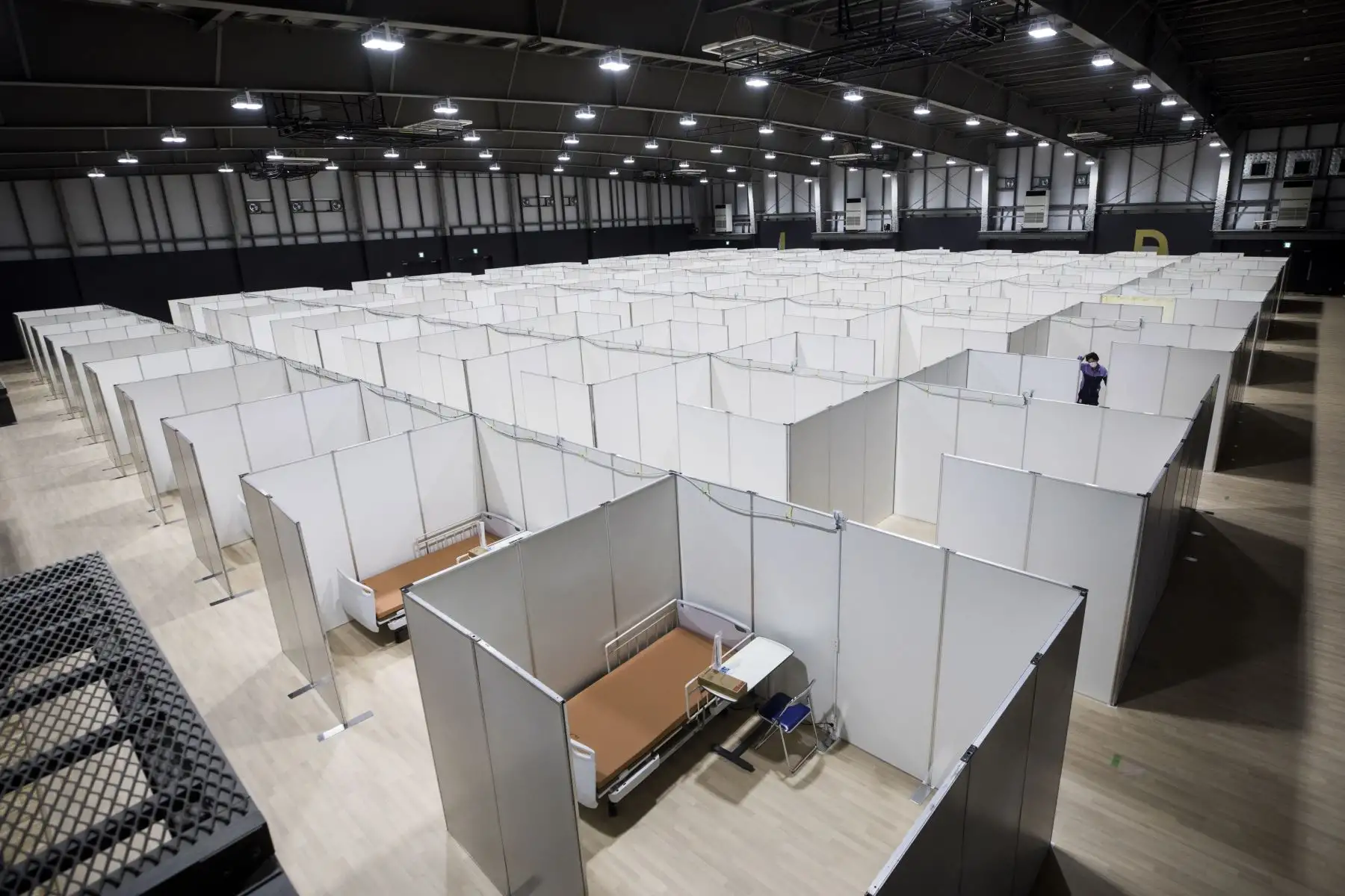 Un empleado trabaja para establecer un centro médico que acomode a pacientes con coronavirus (COVID-19) con síntomas leves en la Fundación Nippon Para Arena en Tokio. Foto: AFP