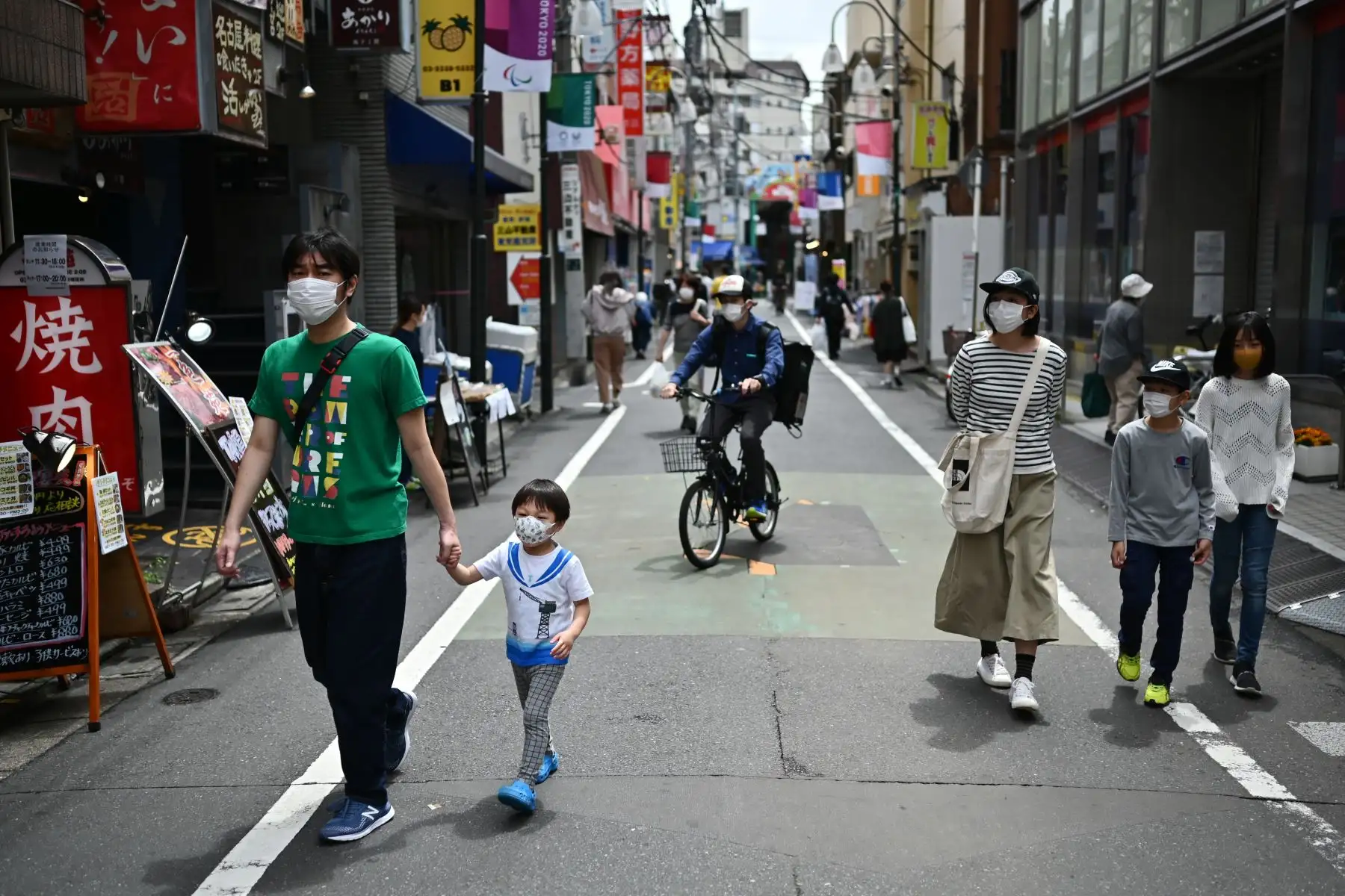 La gente pasa por las tiendas en una zona residencial de Tokio. Foto: AFP