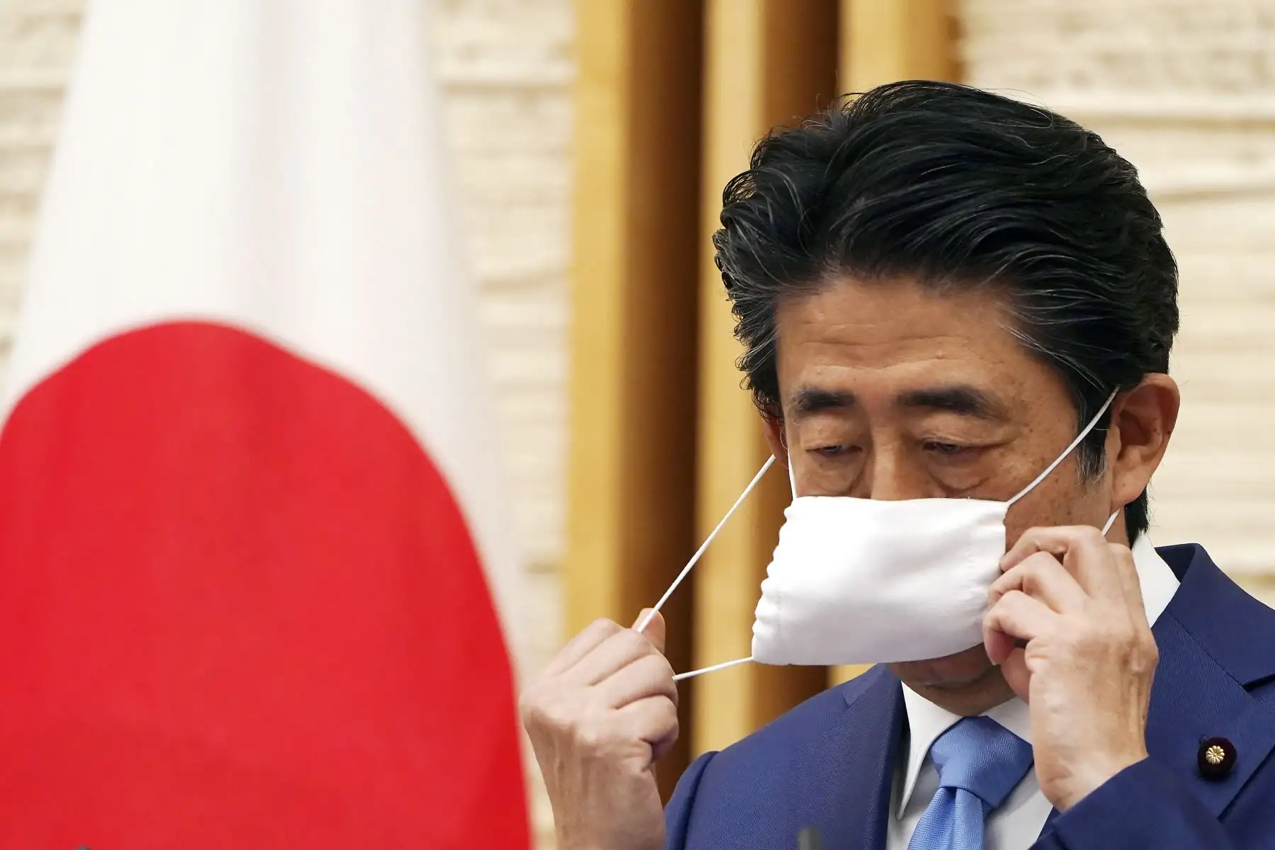 El primer ministro japonés, Shinzo Abe, se quita la máscara facial durante una conferencia de prensa en la oficina del primer ministro en Tokio. Foto: AFP