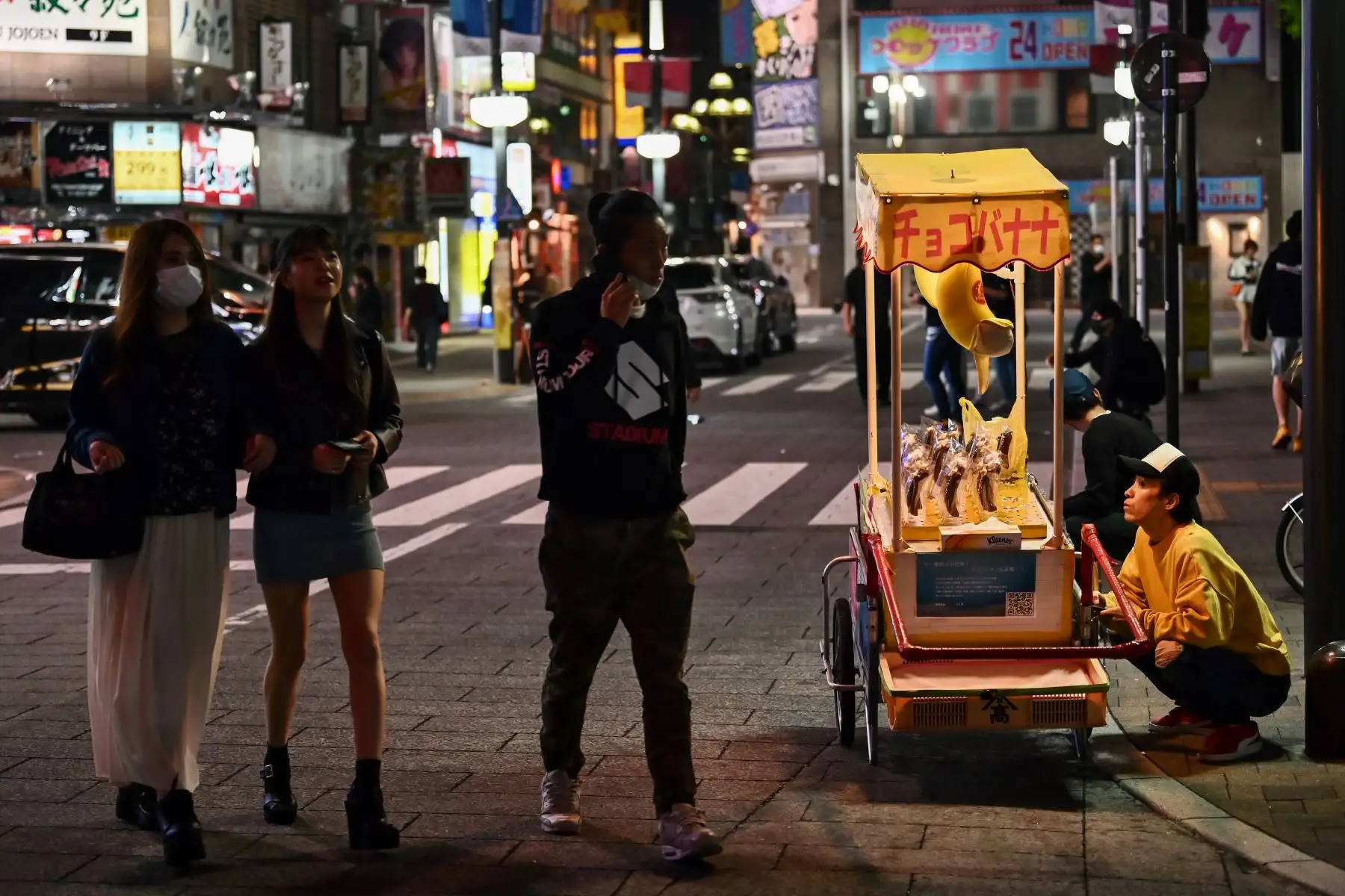 Las personas que usan máscaras faciales en medio de la preocupación por la propagación del coronavirus COVID-19, caminan por la noche por una calle en Tokio el 4 de mayo de 2020. Foto: AFP