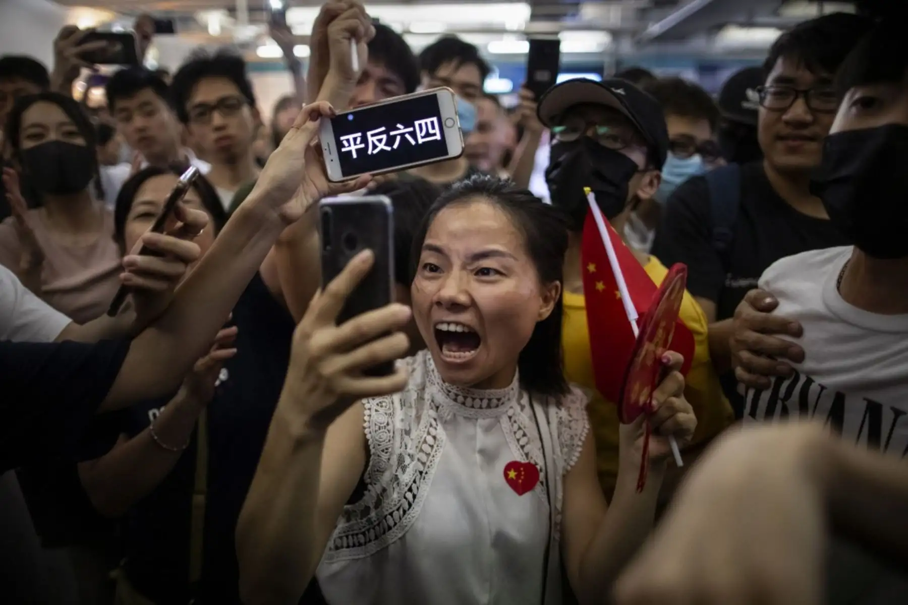 Una manifestante pro China se filma a sí misma mientras una manifestante antigubernamental sostiene un cartel en su teléfono durante las escaramuzas entre los dos grupos opositores en la estación de Yuen Long en Hong Kong, China. Foto: Reuters/Pulitzer