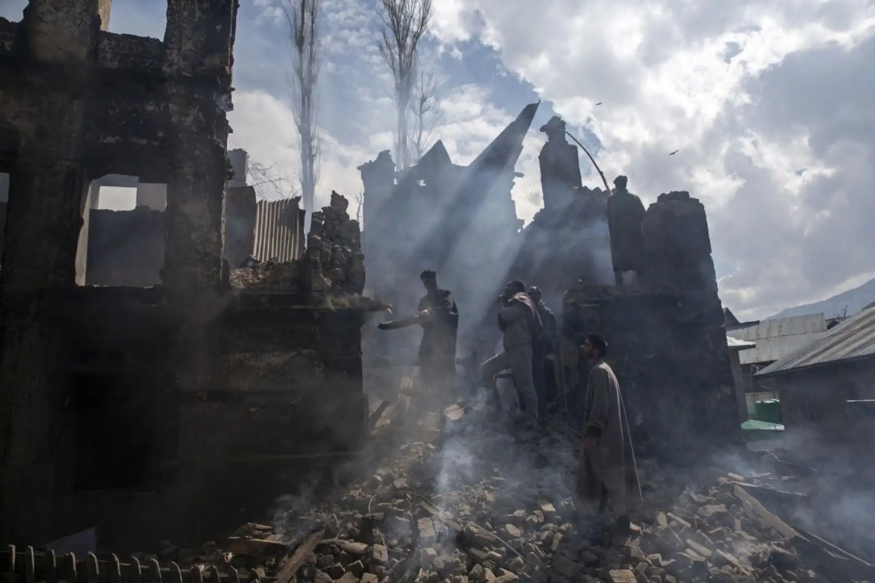 Hombres Kashmires desmantelan una parte de una casa destruida en un tiroteo en la aldea de Tral, al sur de Srinagar, Cachemira controlada por los indios. Foto: AP/Pulitzer
